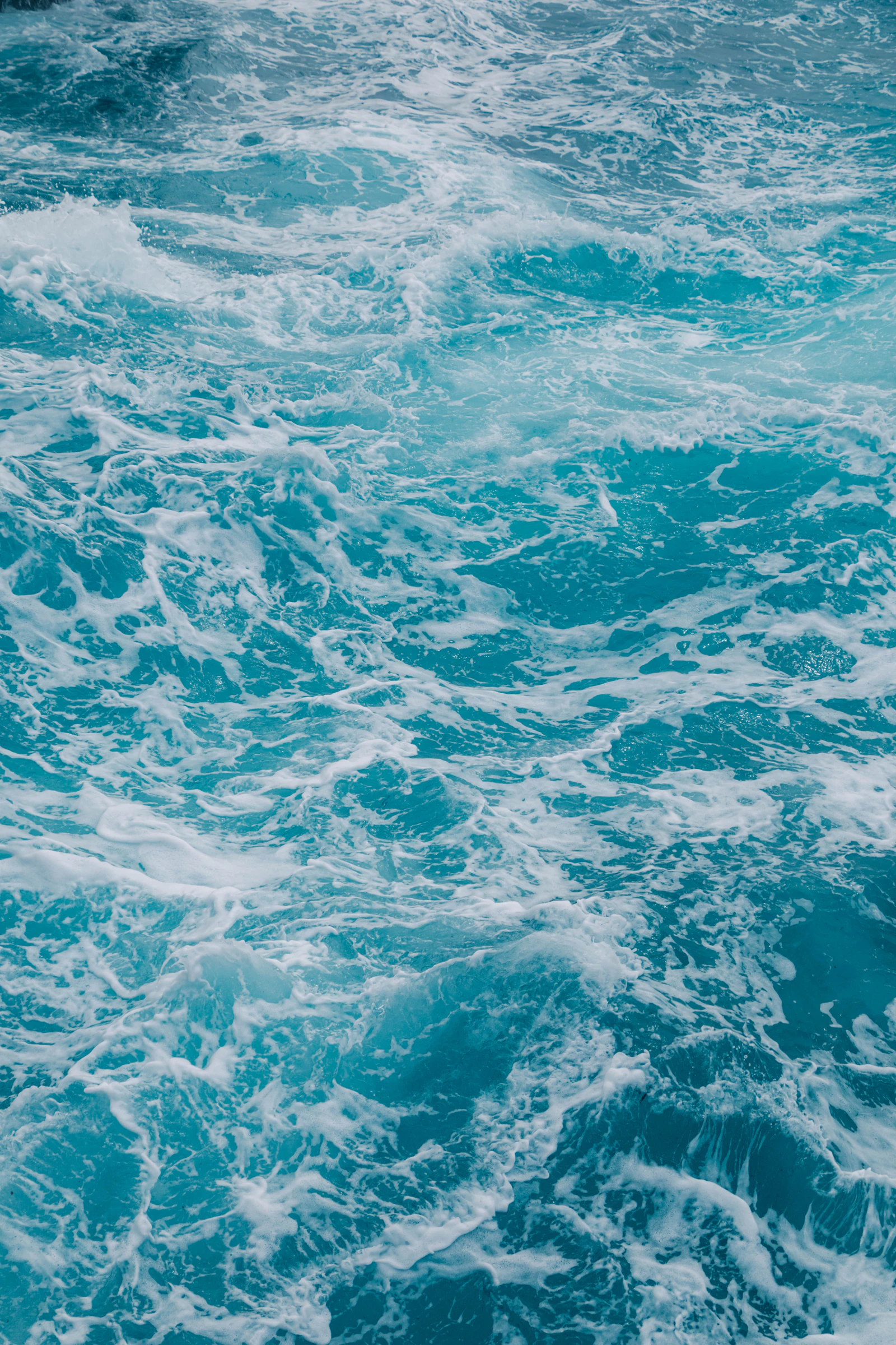 Acqua di mare turchese increspata con schiuma bianca