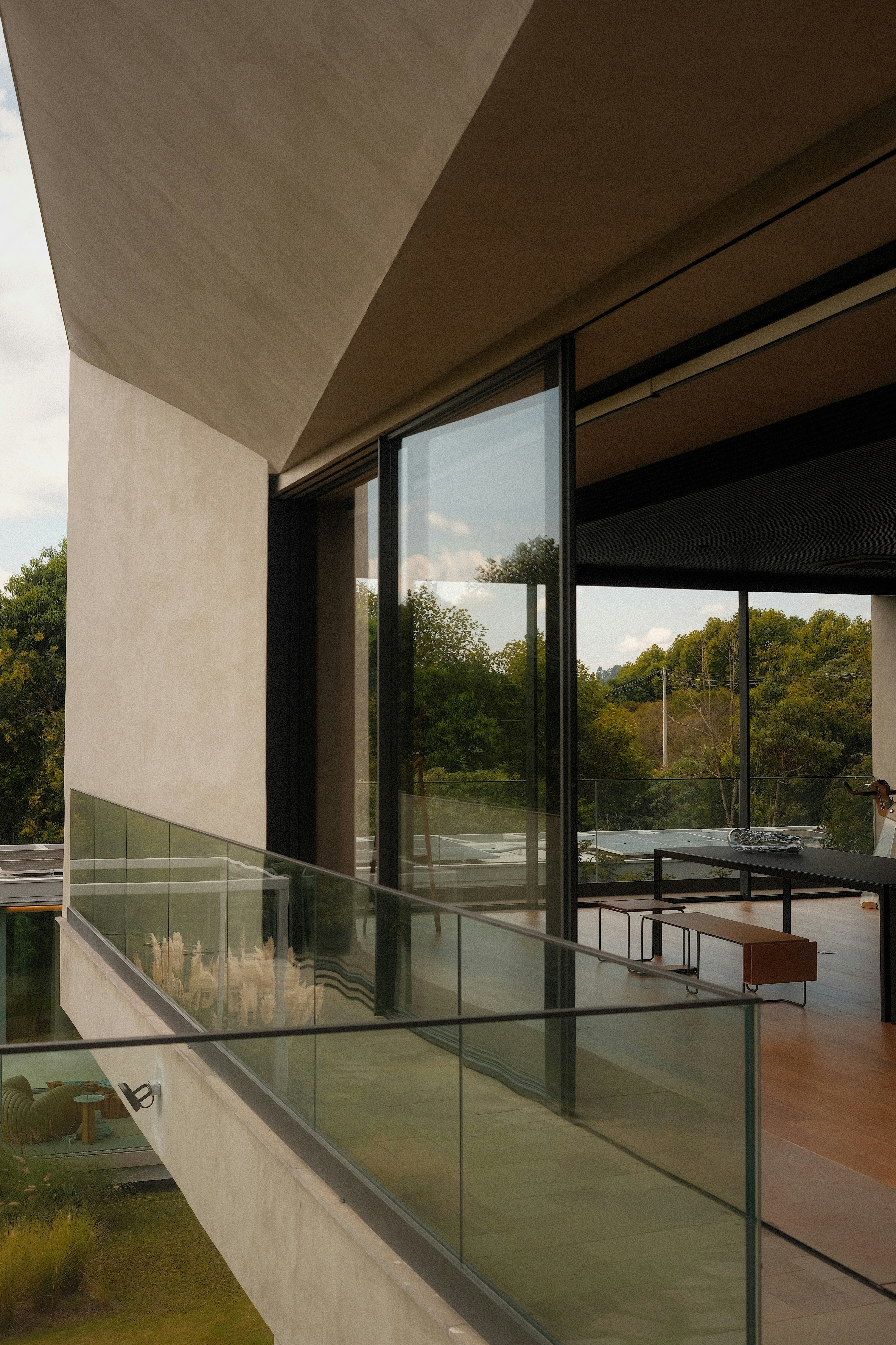 Modern house with large windows and a balcony.