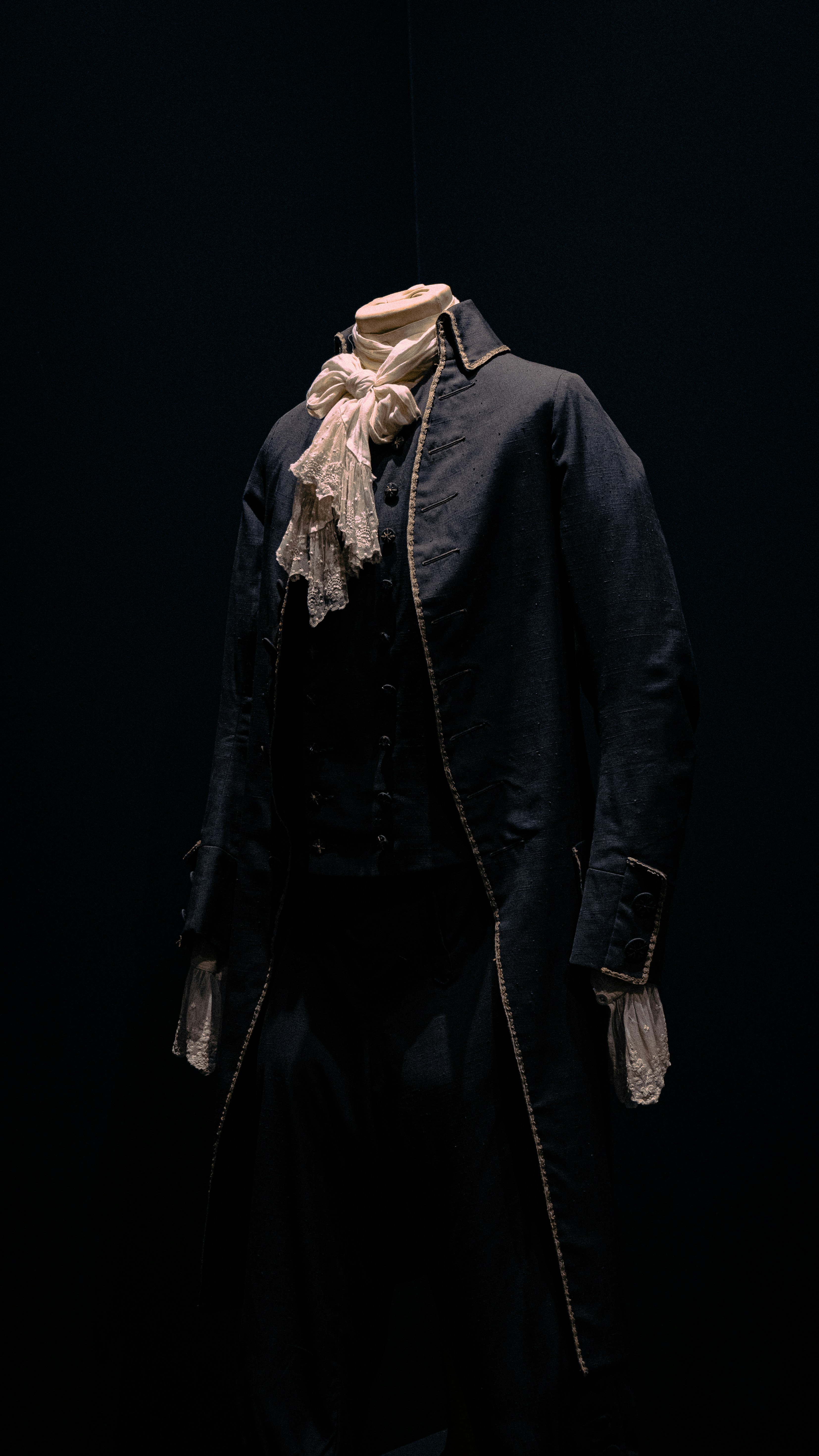 Historical coat displayed with a neck and a white cravat.