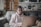 Woman works on laptop while sitting on a couch.
