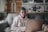 Woman works on laptop while sitting on a couch.