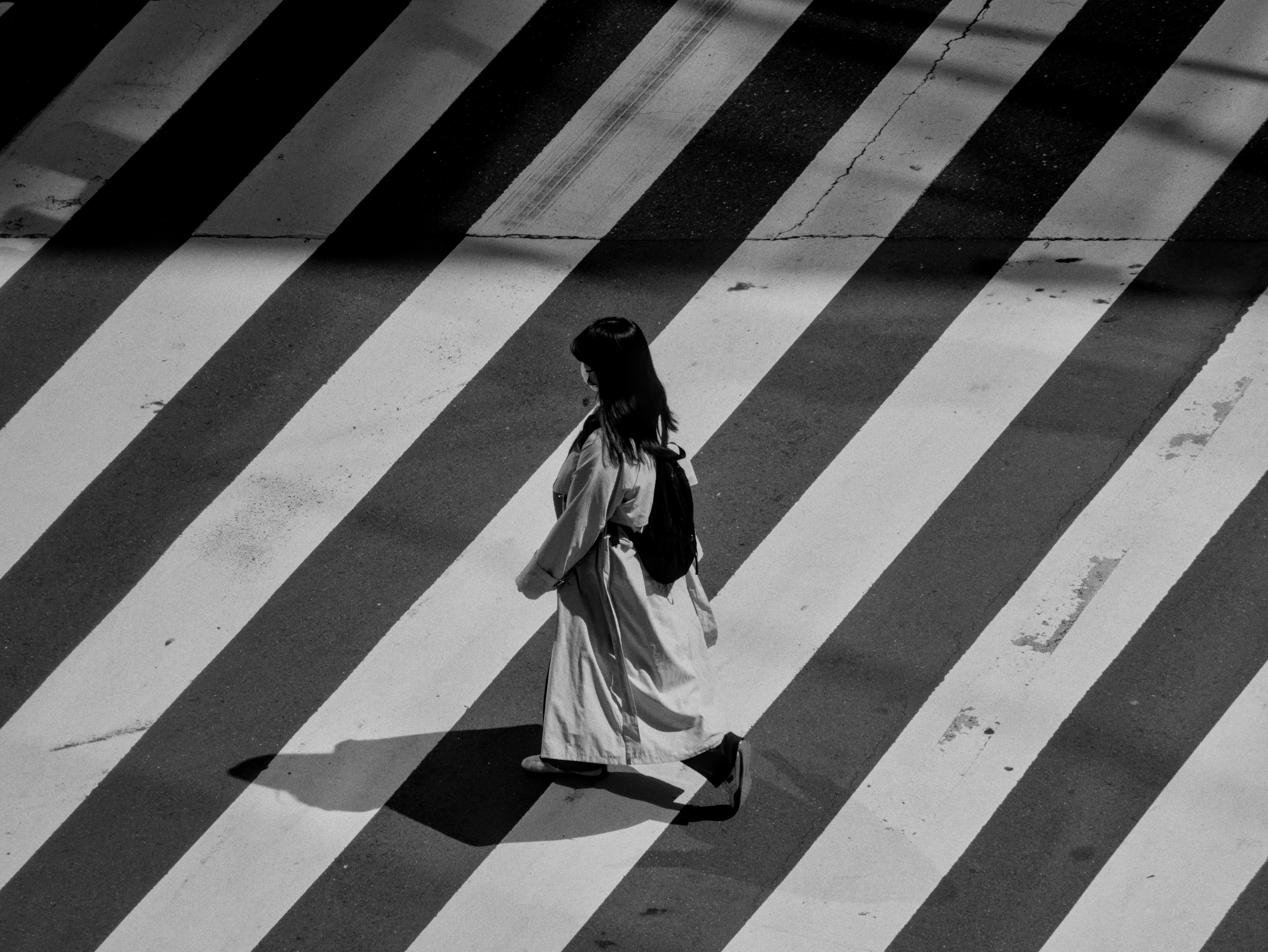 Woman crosses a zebra crossing in black and white.