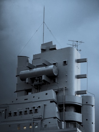 A modern, grey building against a stormy sky.