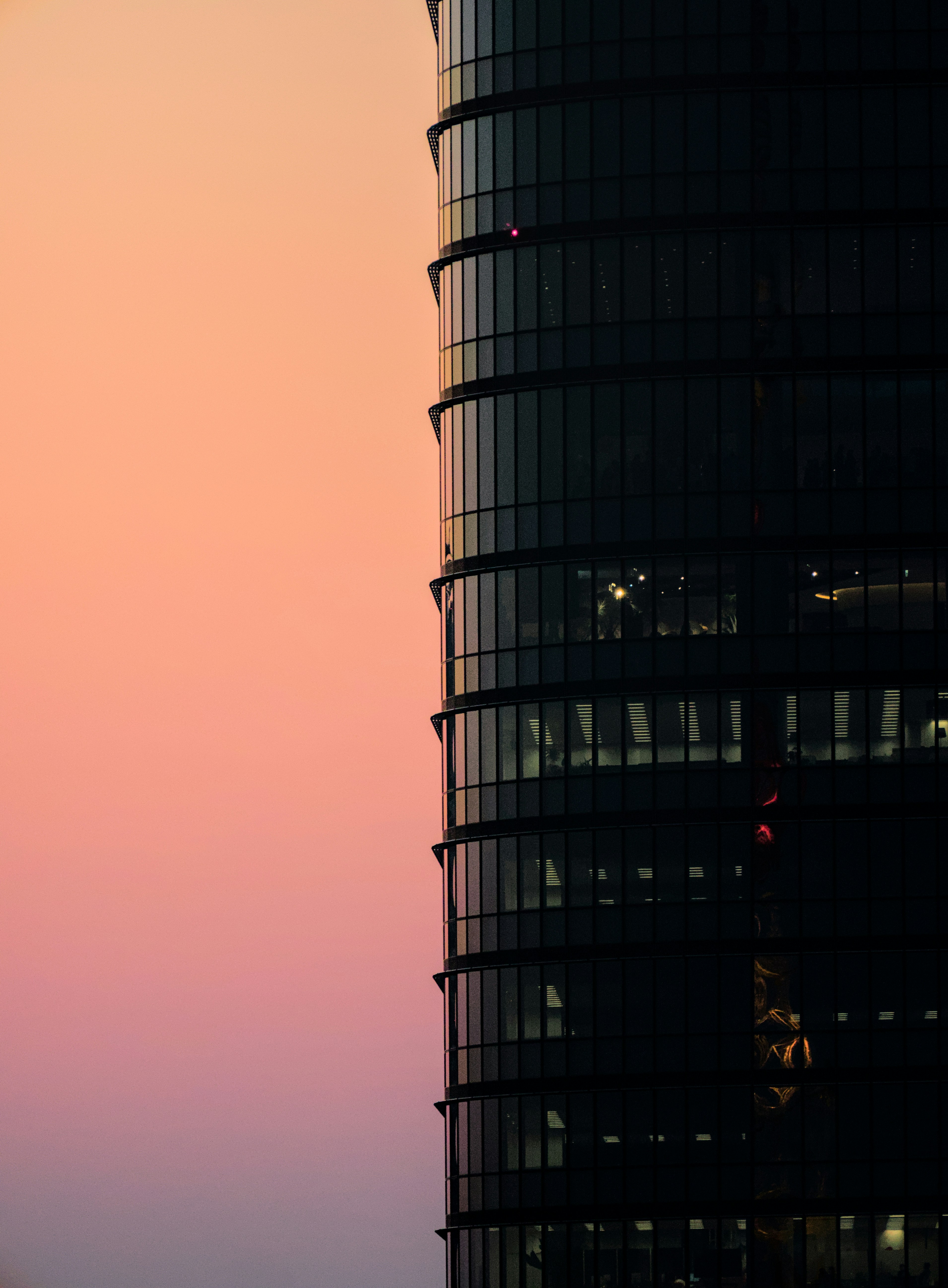 A tall building stands silhouetted against sunset.