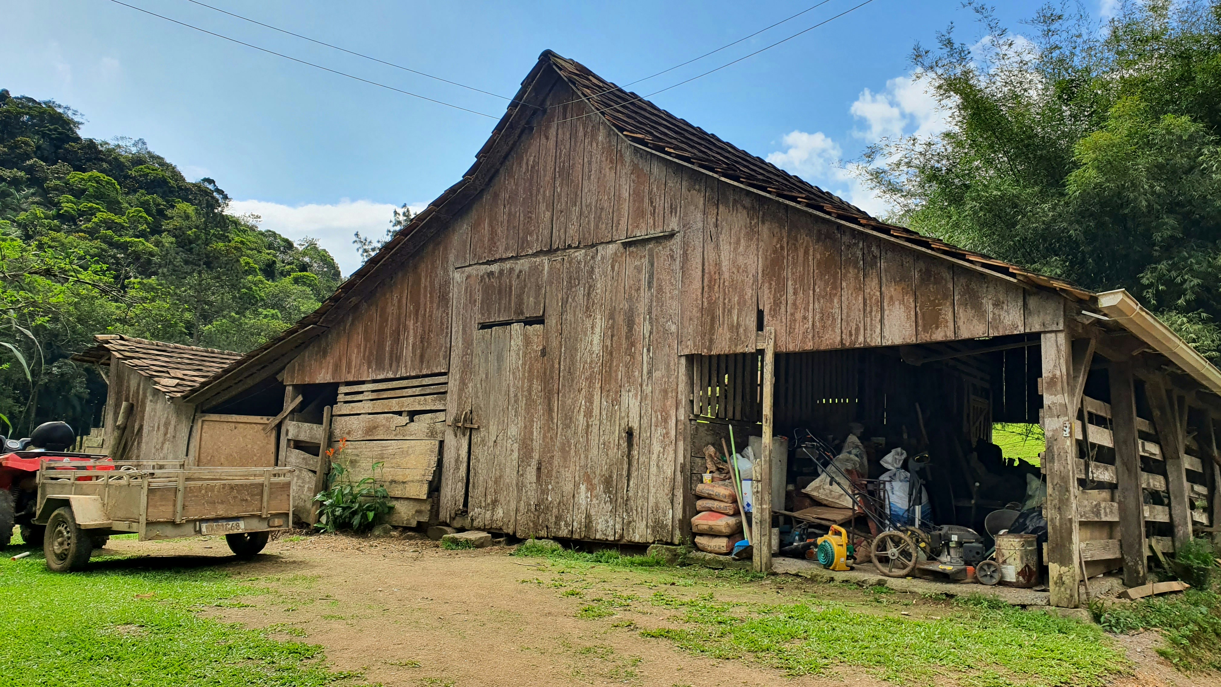 Old wooden barn sits on a grassy field.