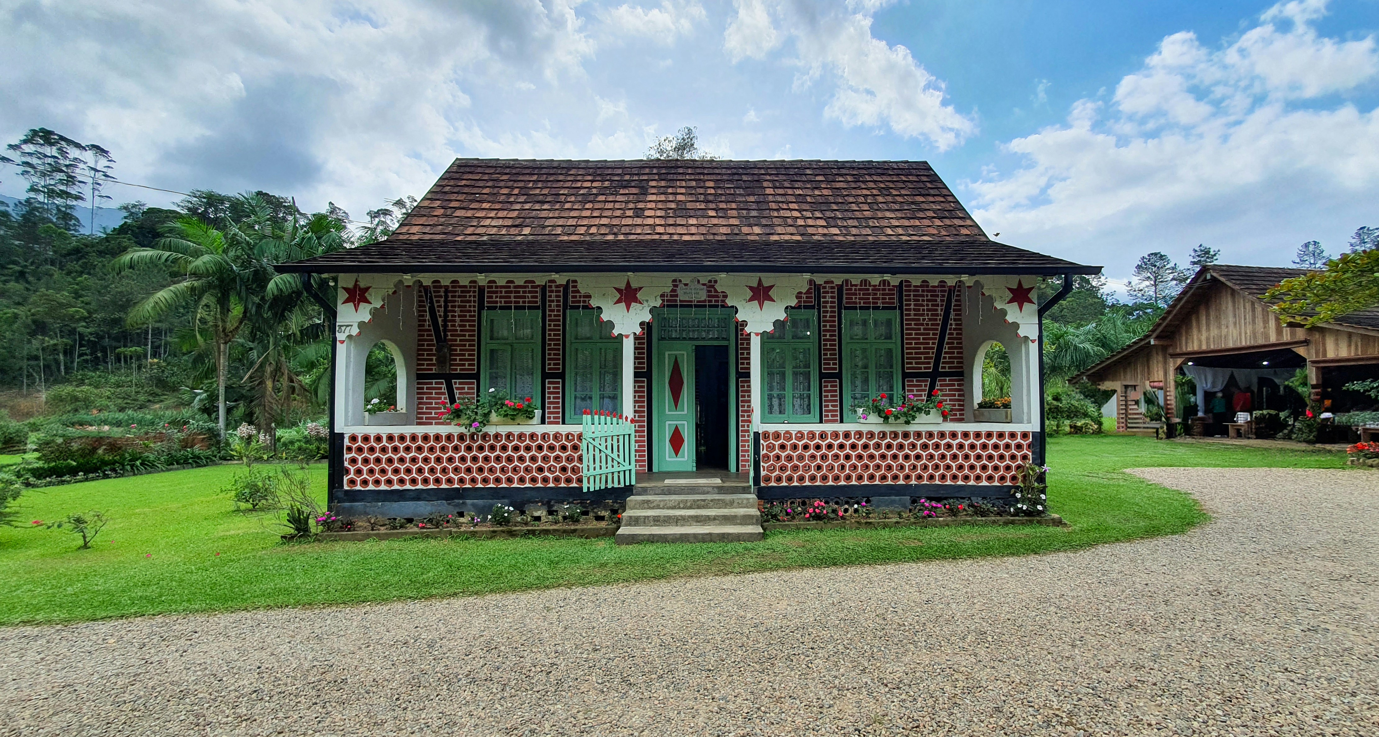 Quaint house sits amidst a lush green landscape.
