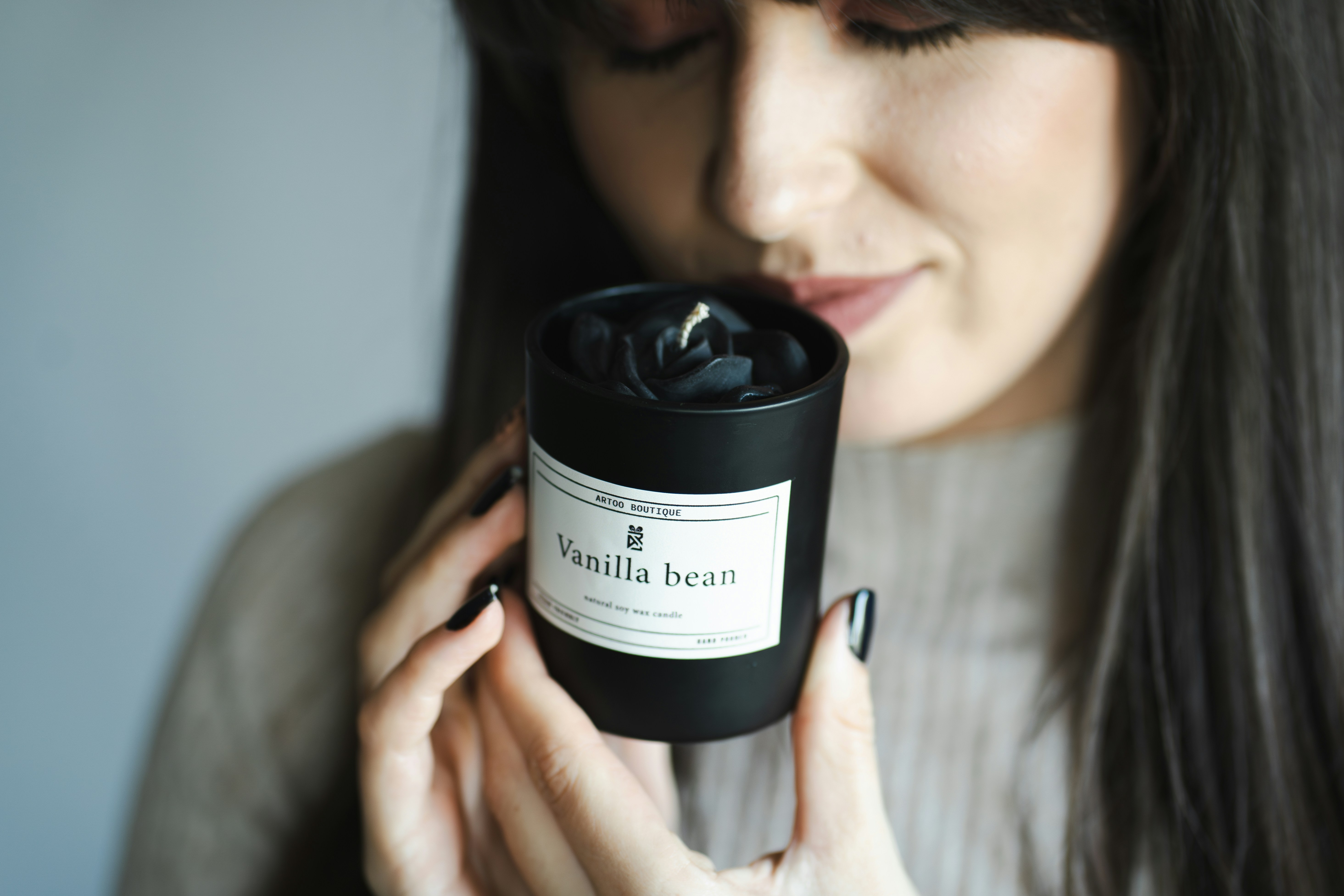 Woman smelling a "vanilla bean" scented candle.