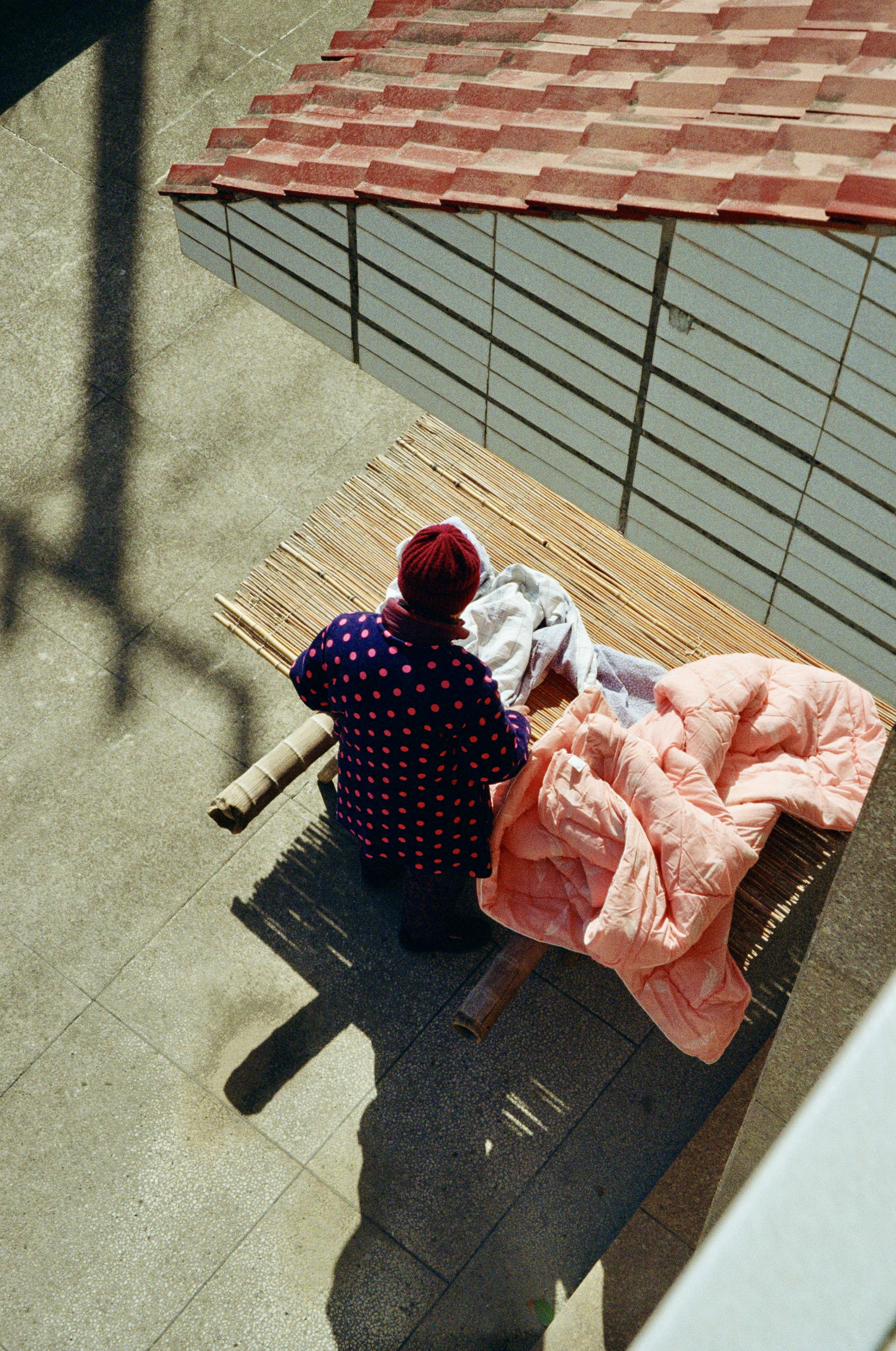 Woman folds laundry outside on a sunny day.