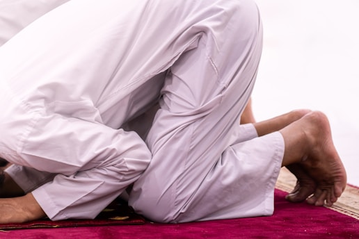 Muslim man is praying on a rug.