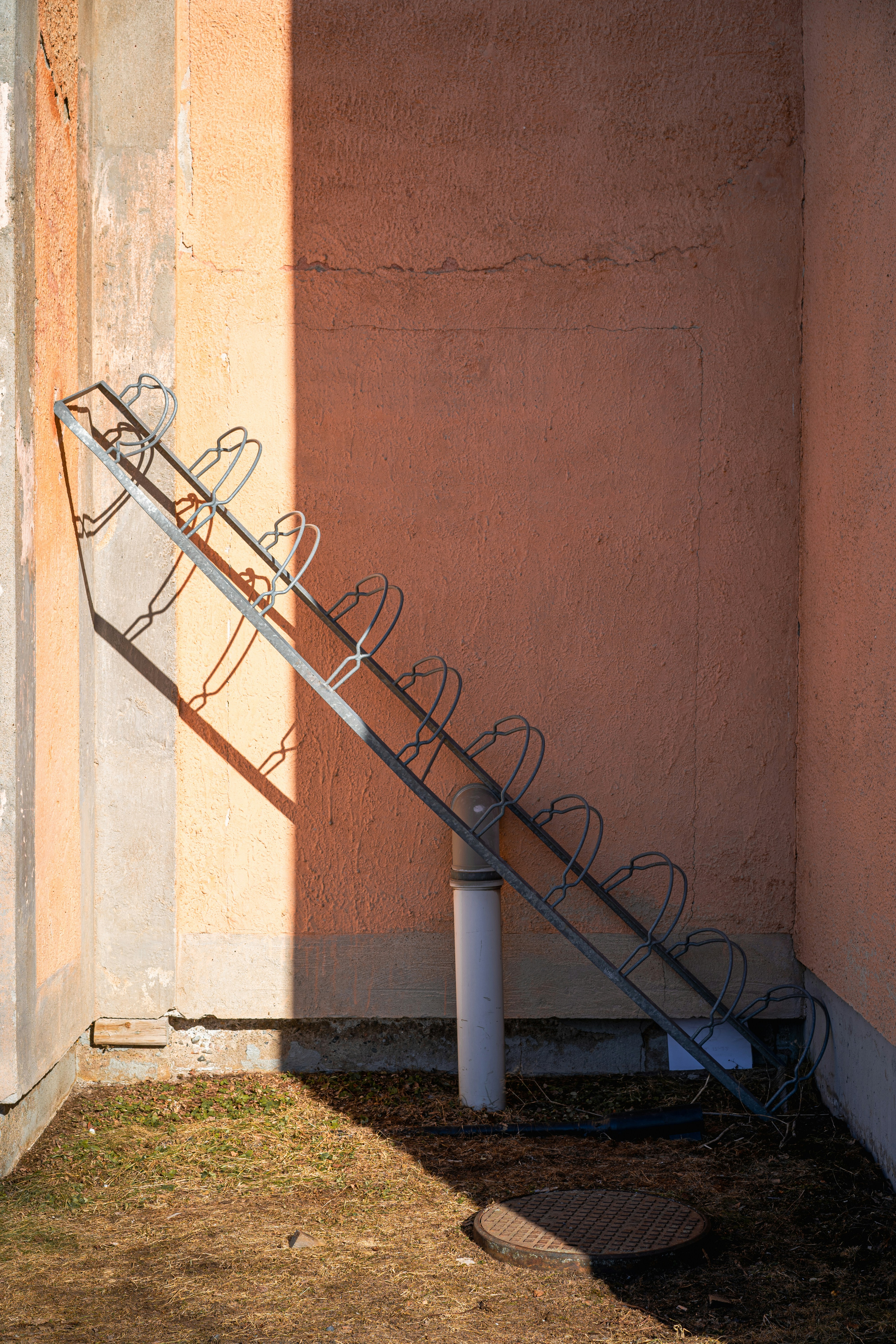 A bike rack stands against a peach-colored wall. photo – Free Texture ...