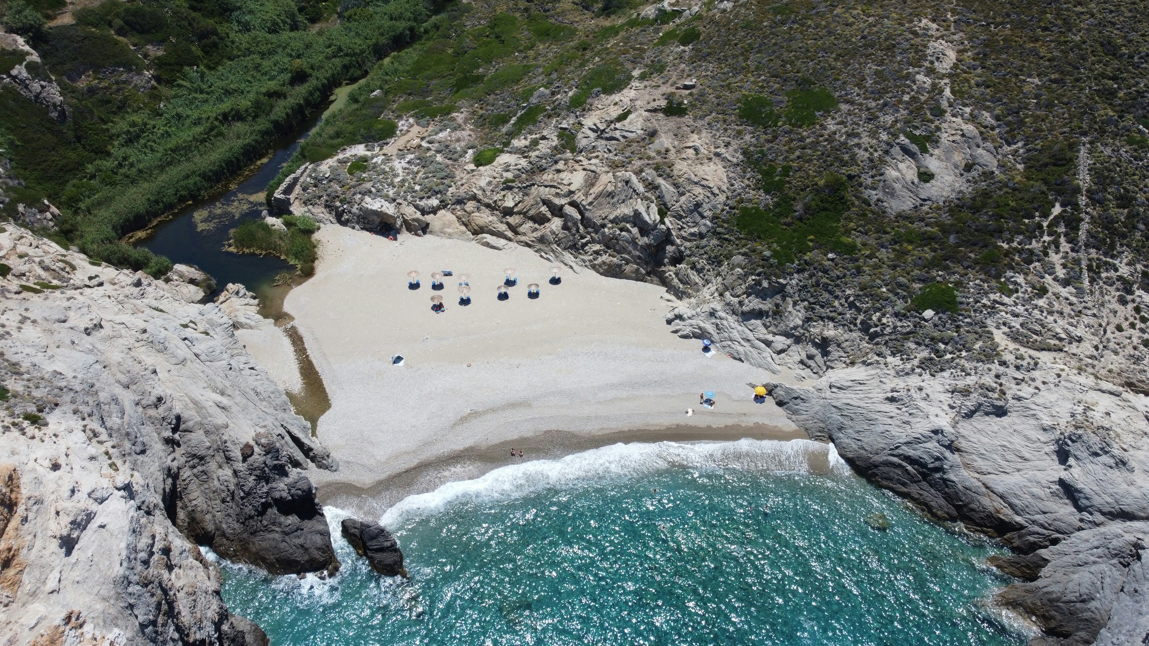A scenic beach surrounded by rocky cliffs.