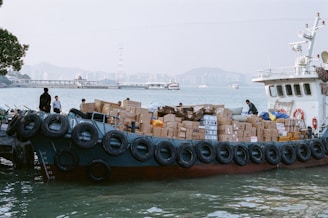A boat is loaded with boxes near the pier.
