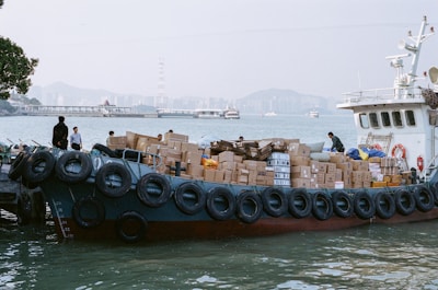 A boat is loaded with boxes near the pier.