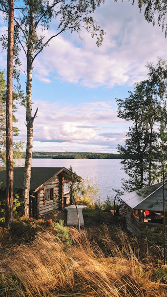 A cabin by the lake under a cloudy sky