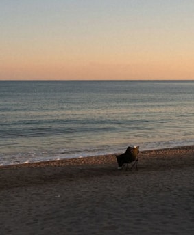 Chair sits peacefully on the calm beach looking out a the sea