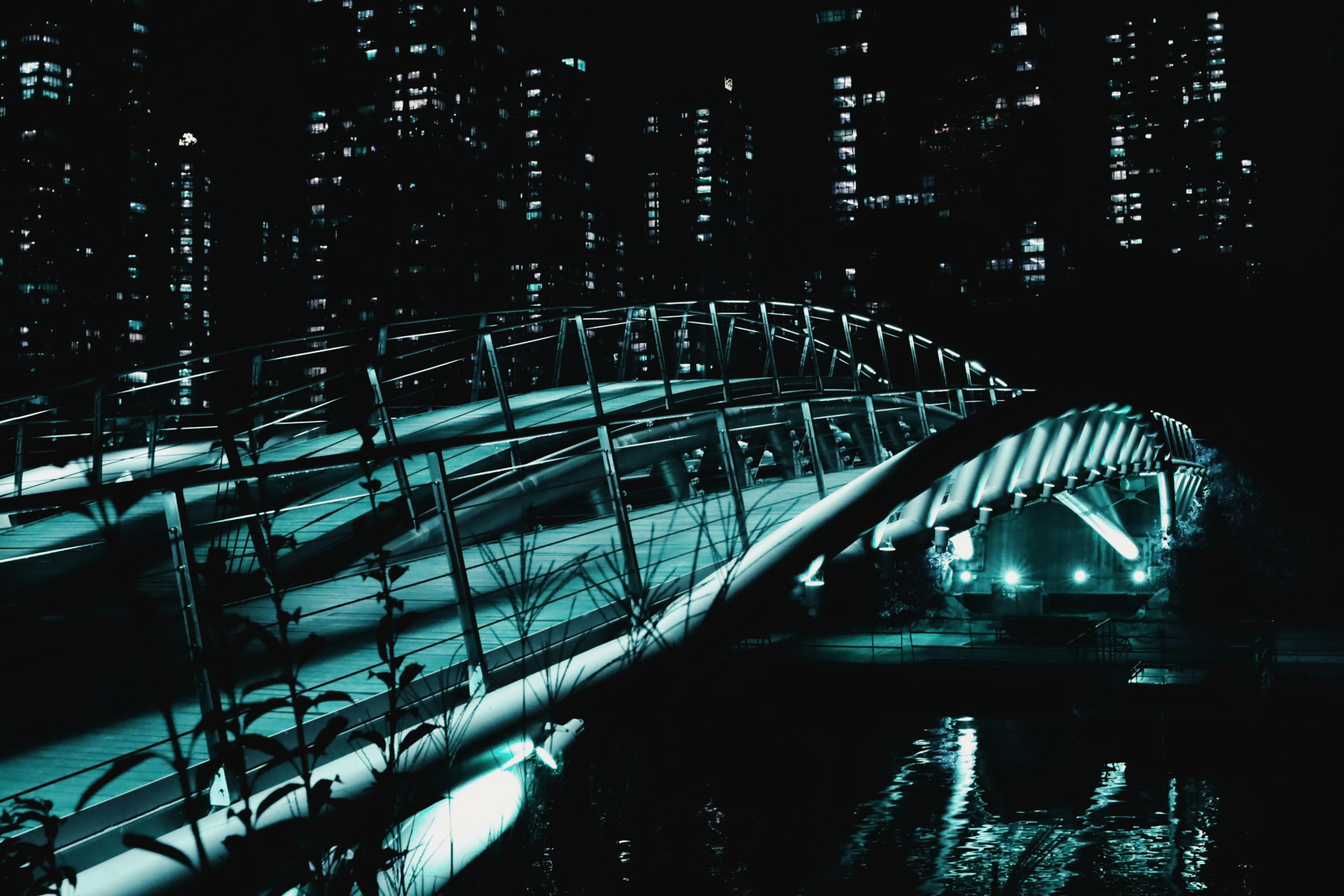 A lit-up bridge spans across the night city.