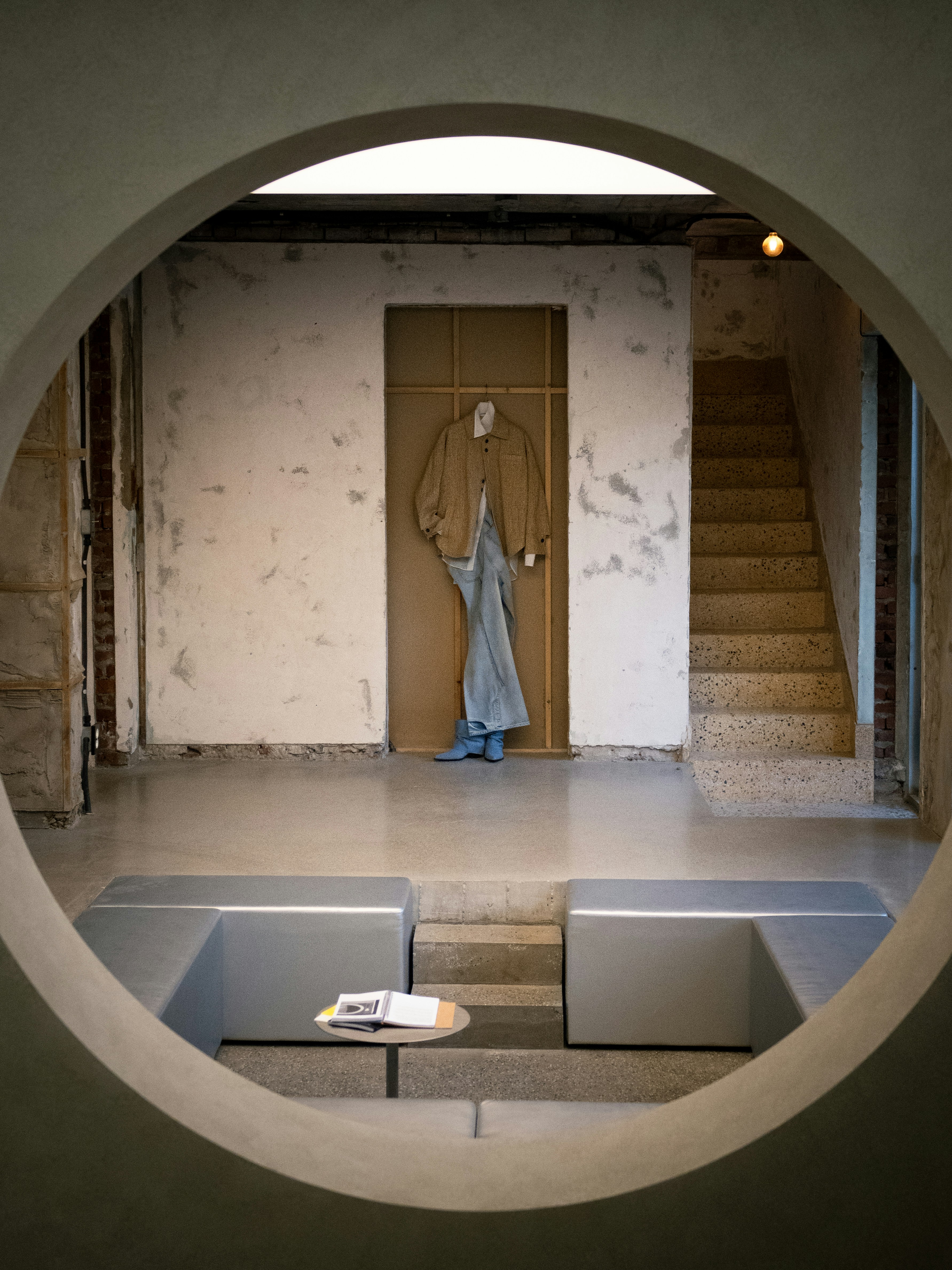 Clothing is displayed in a modern, minimalist space.