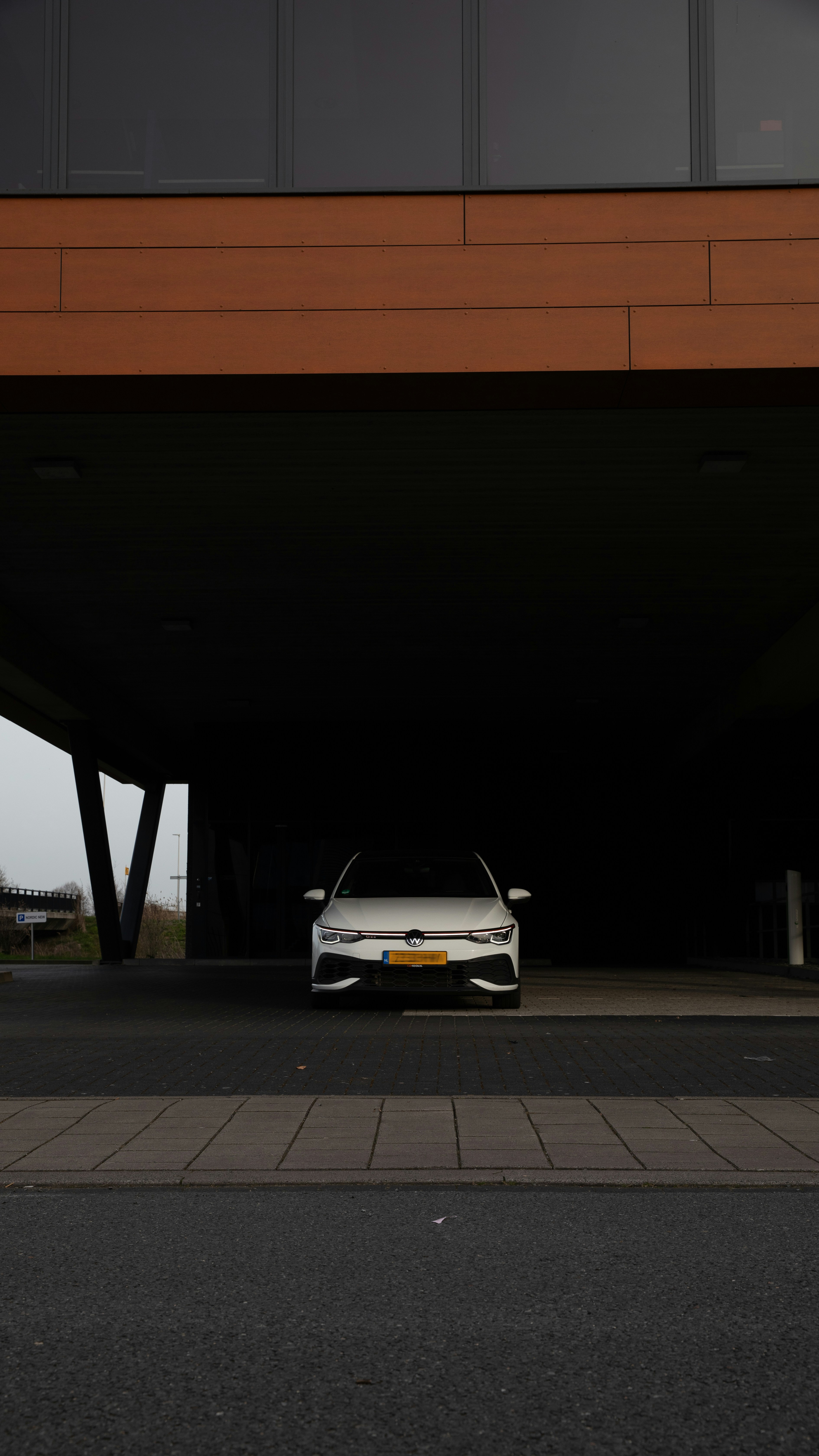 A white car parked under a structure.