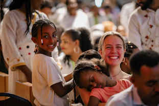 People are smiling at a festive, joyful gathering.
