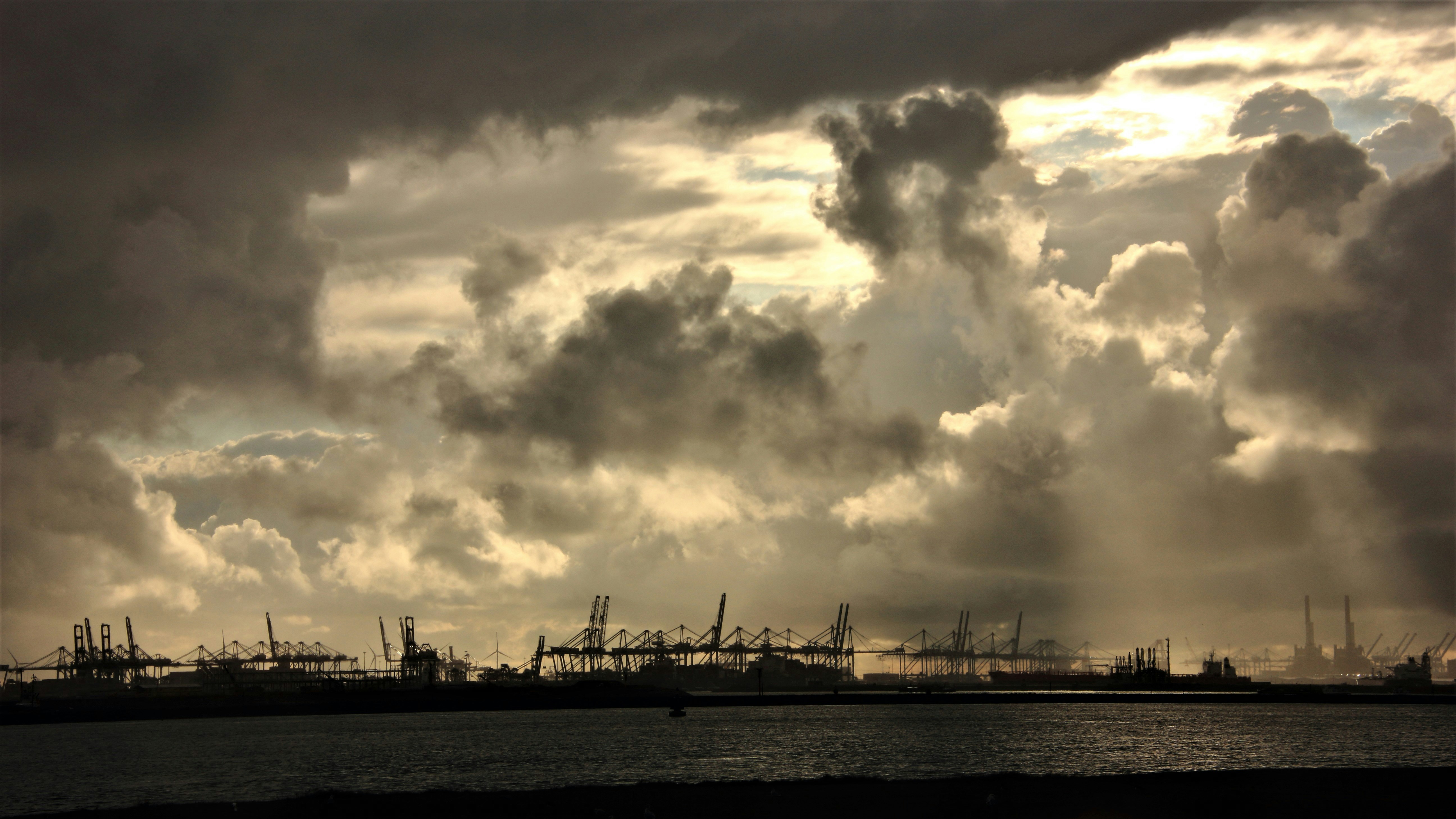 Dramatische Wolken über einer Hafenszenerie.