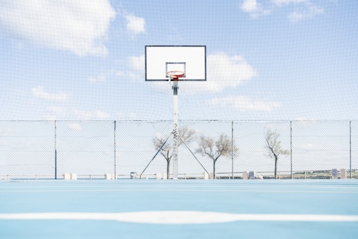 Basketball hoop stands on blue court.