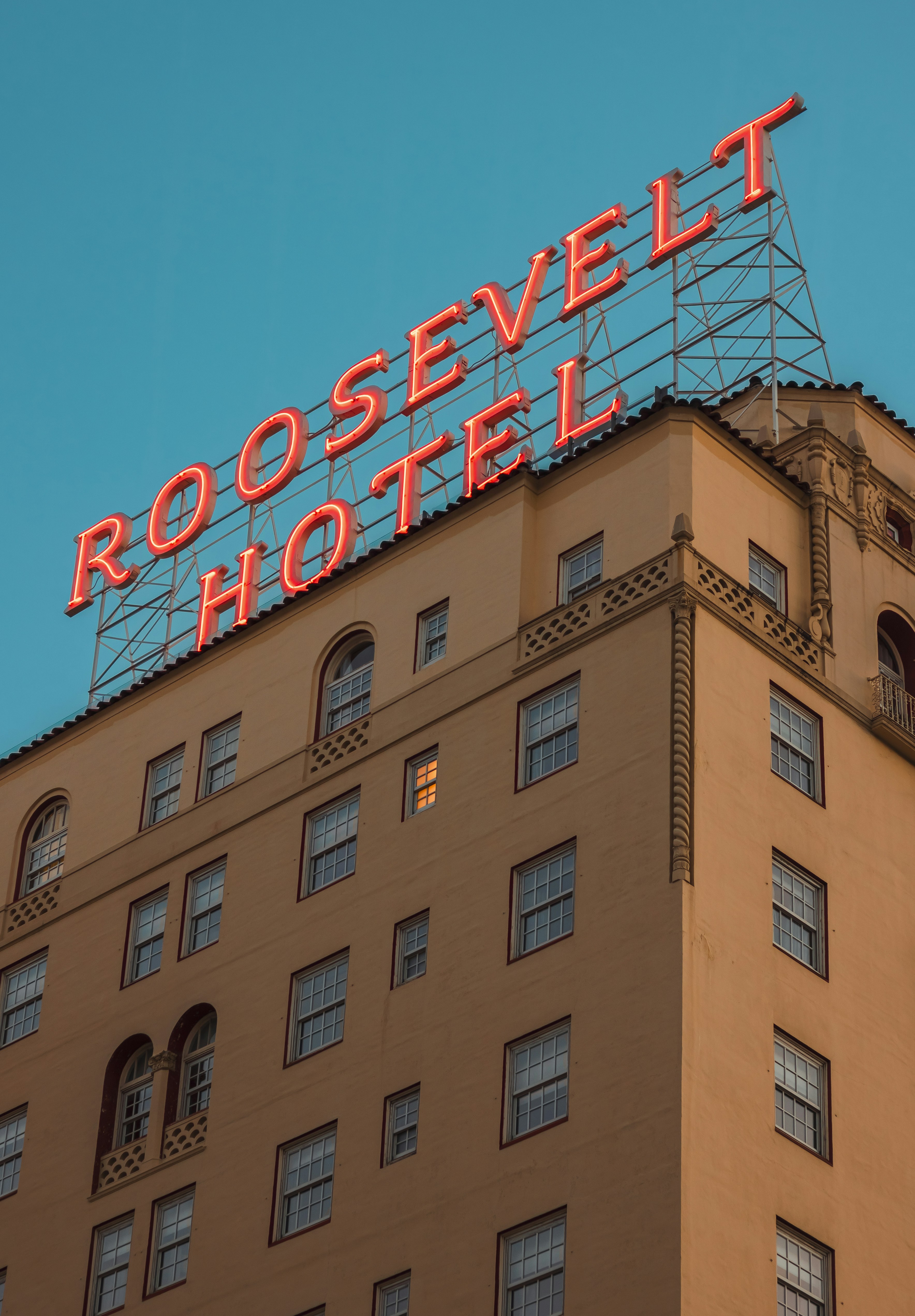 The roosevelt hotel's neon sign shines brightly.