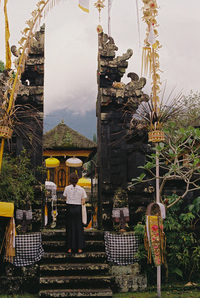 lingam massage in Bali, a carved Balinese temple gateway under misty hills