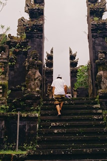 A person walks up steps towards a gate.
