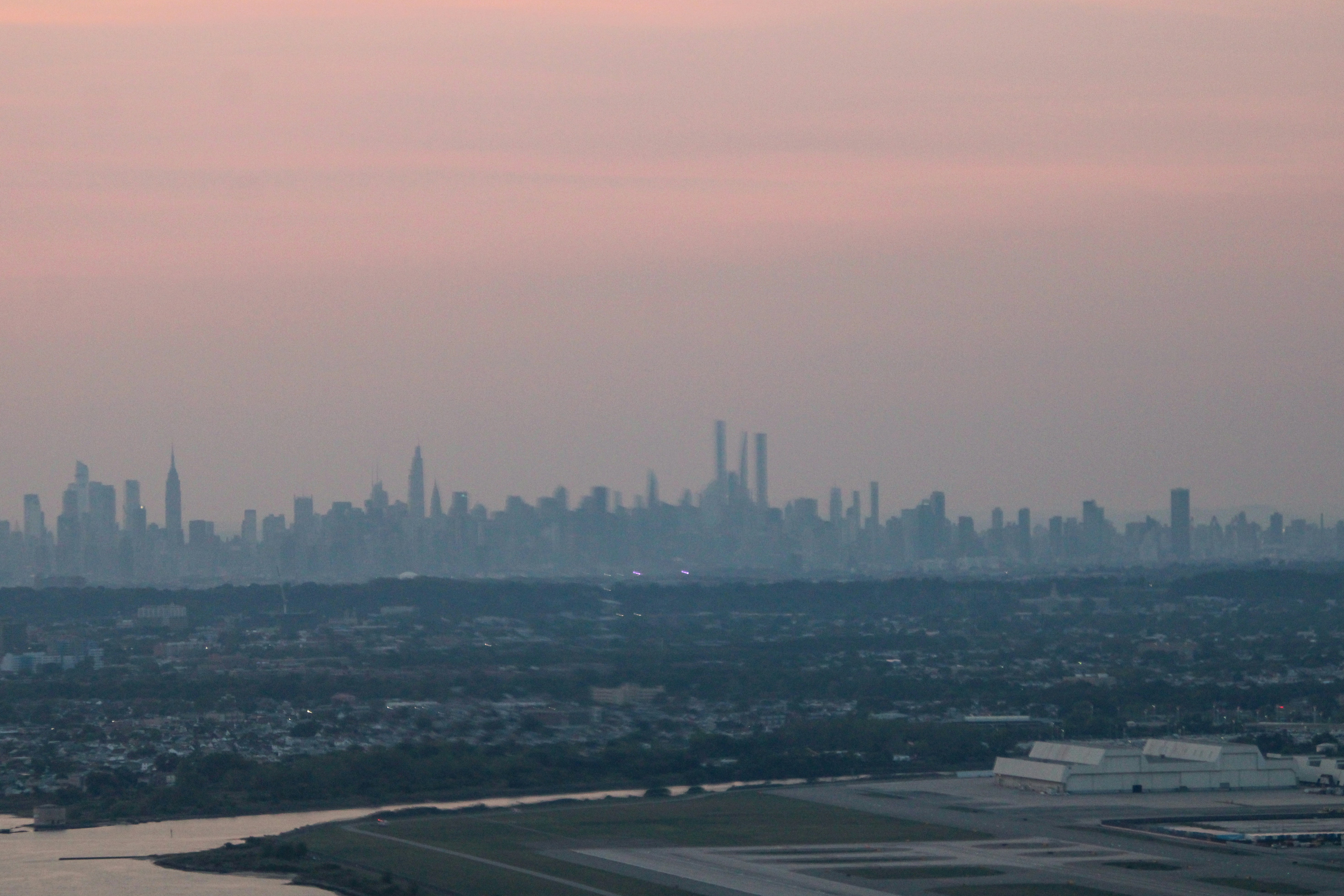 Distant city skyline during a pastel sunset.