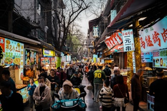 A bustling asian street market is filled with people.