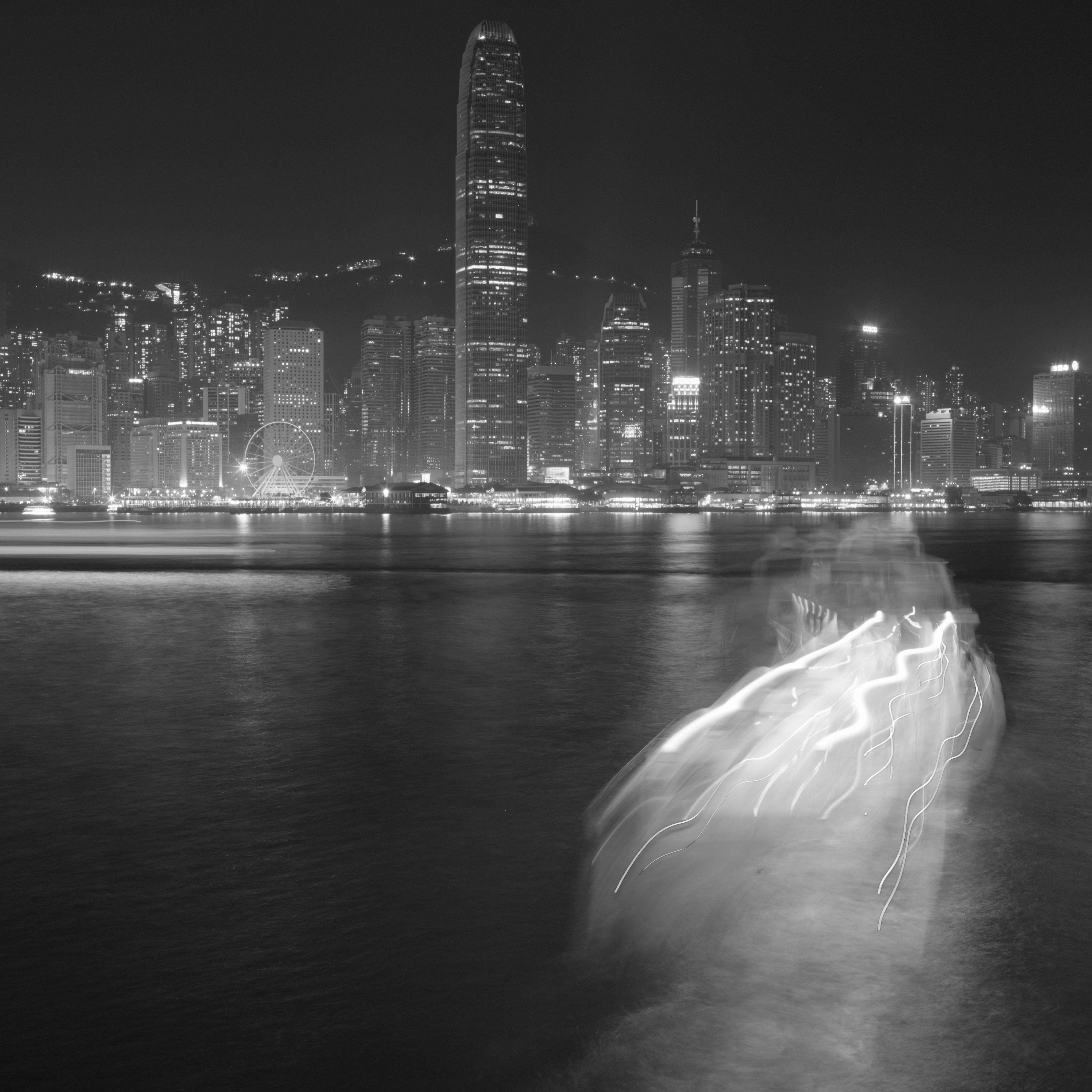 Nighttime cityscape with blurred boat lights.