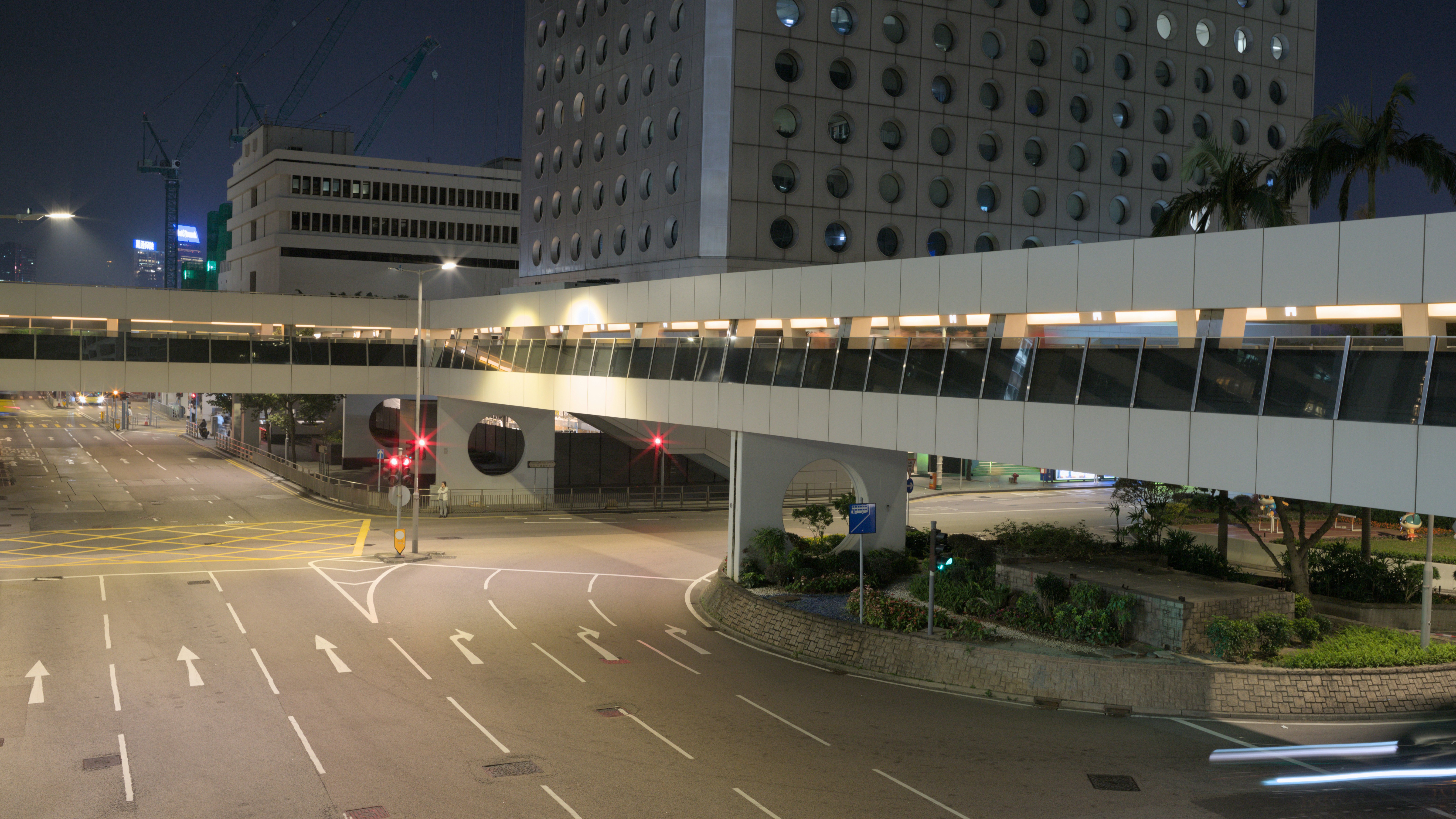 A pedestrian bridge over a city street at night.