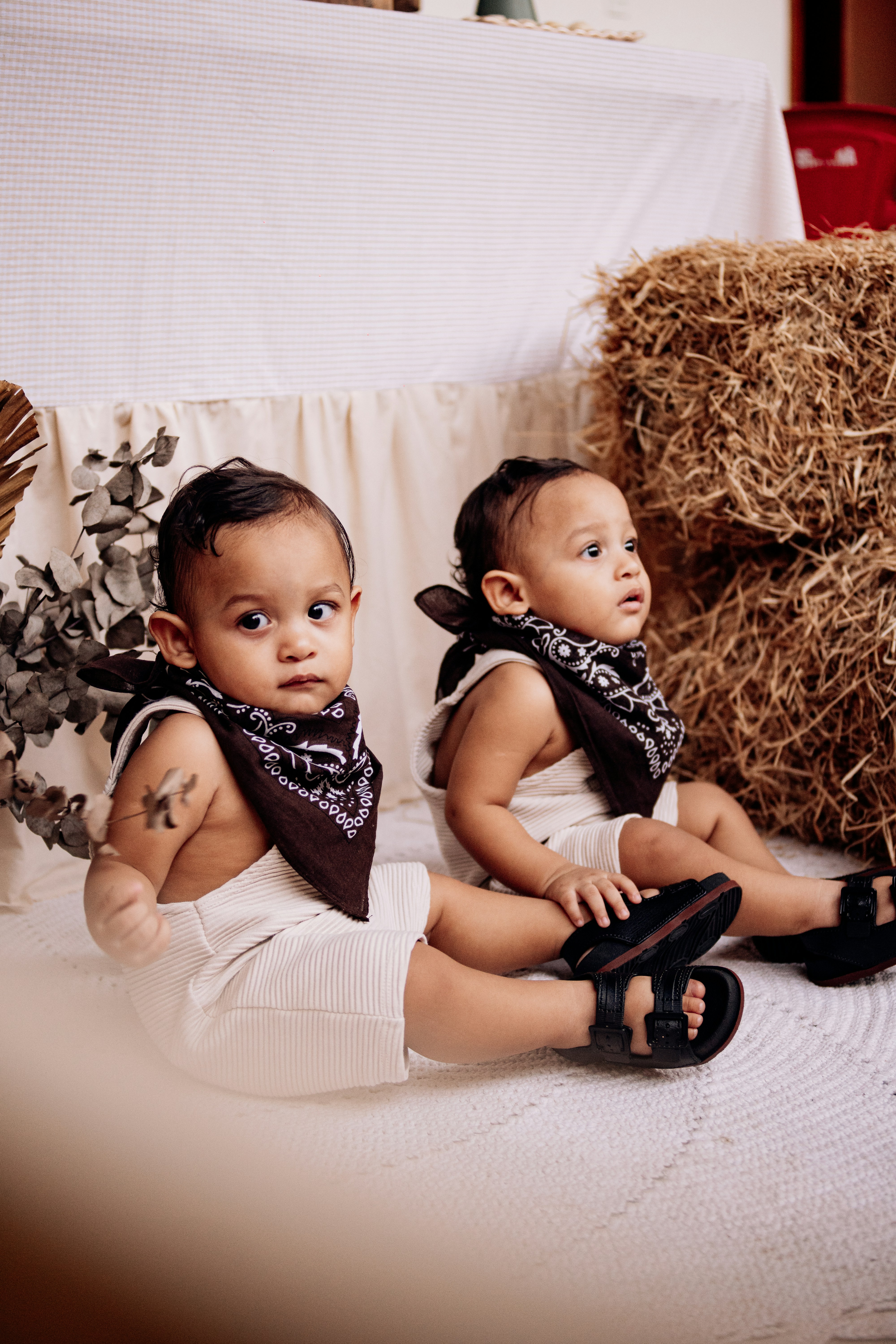 Dos bebés con pañuelos posan para la cámara.
