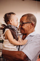 Grandfather lovingly holds his adorable grandchild.