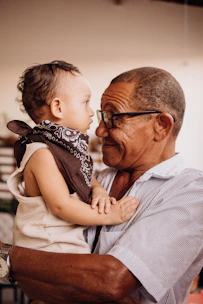 Grandfather lovingly holds his adorable grandchild.