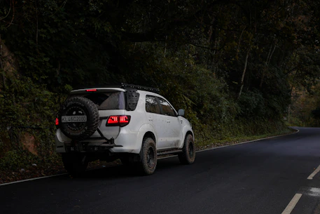 White suv driving down a winding road.