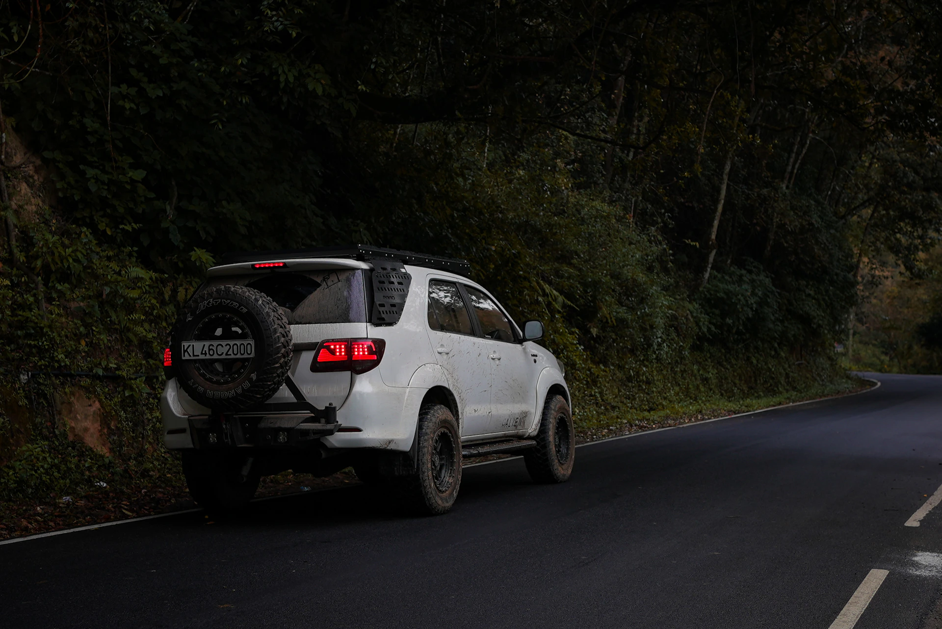 White suv driving down a winding road.