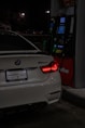 A white BMW m4 is refueling at night.