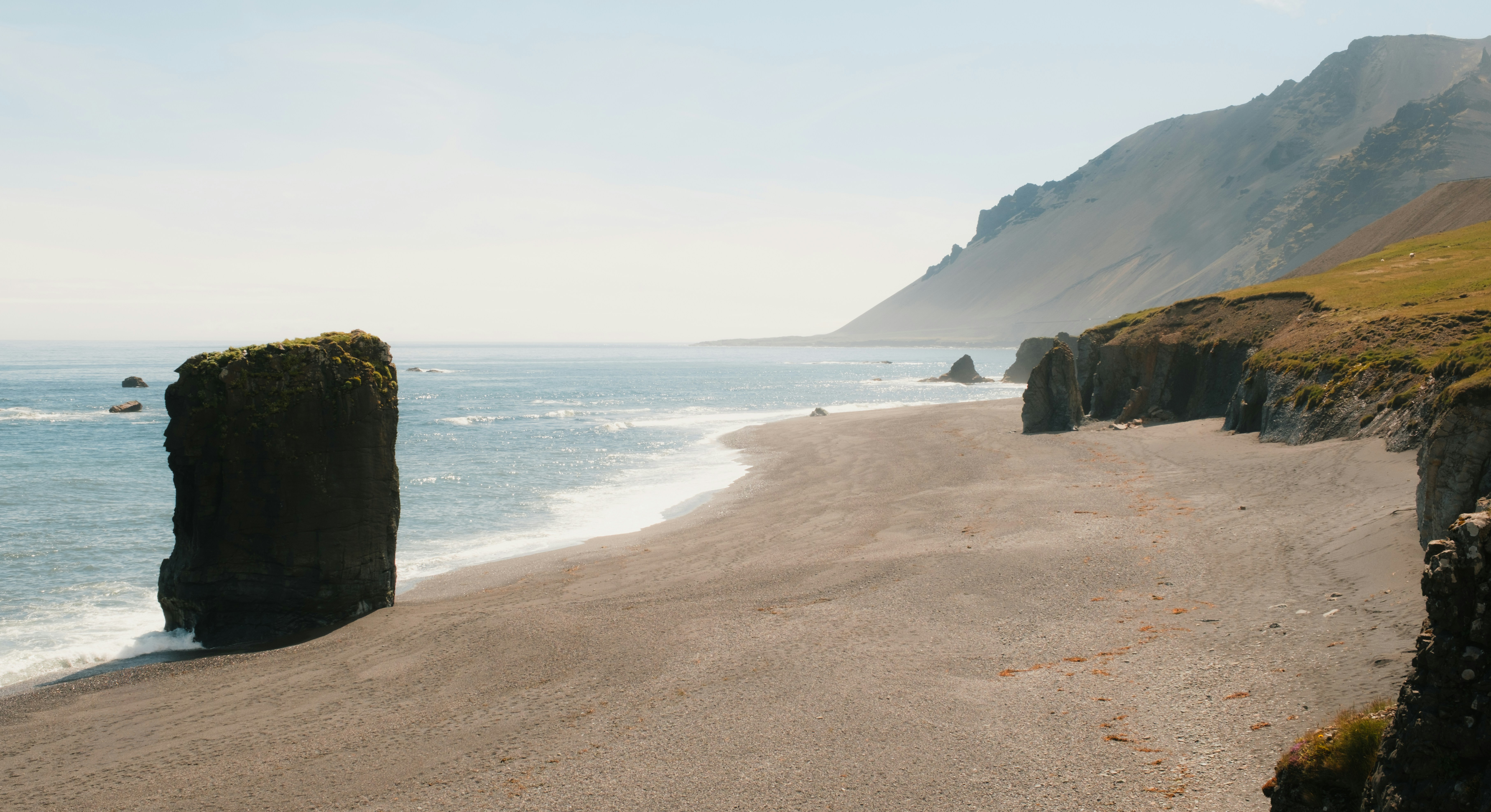 Rocky beach and ocean under a bright sky.