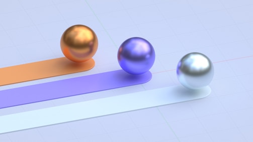Three colored spheres roll along different paths.