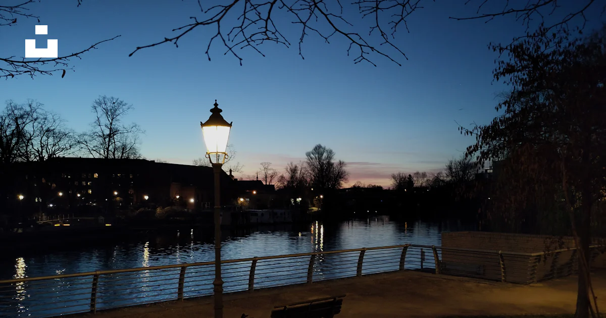 Unsplash Image Riverside A lamp illuminates a riverside park at dusk. photo – Free Sunset Image ...
