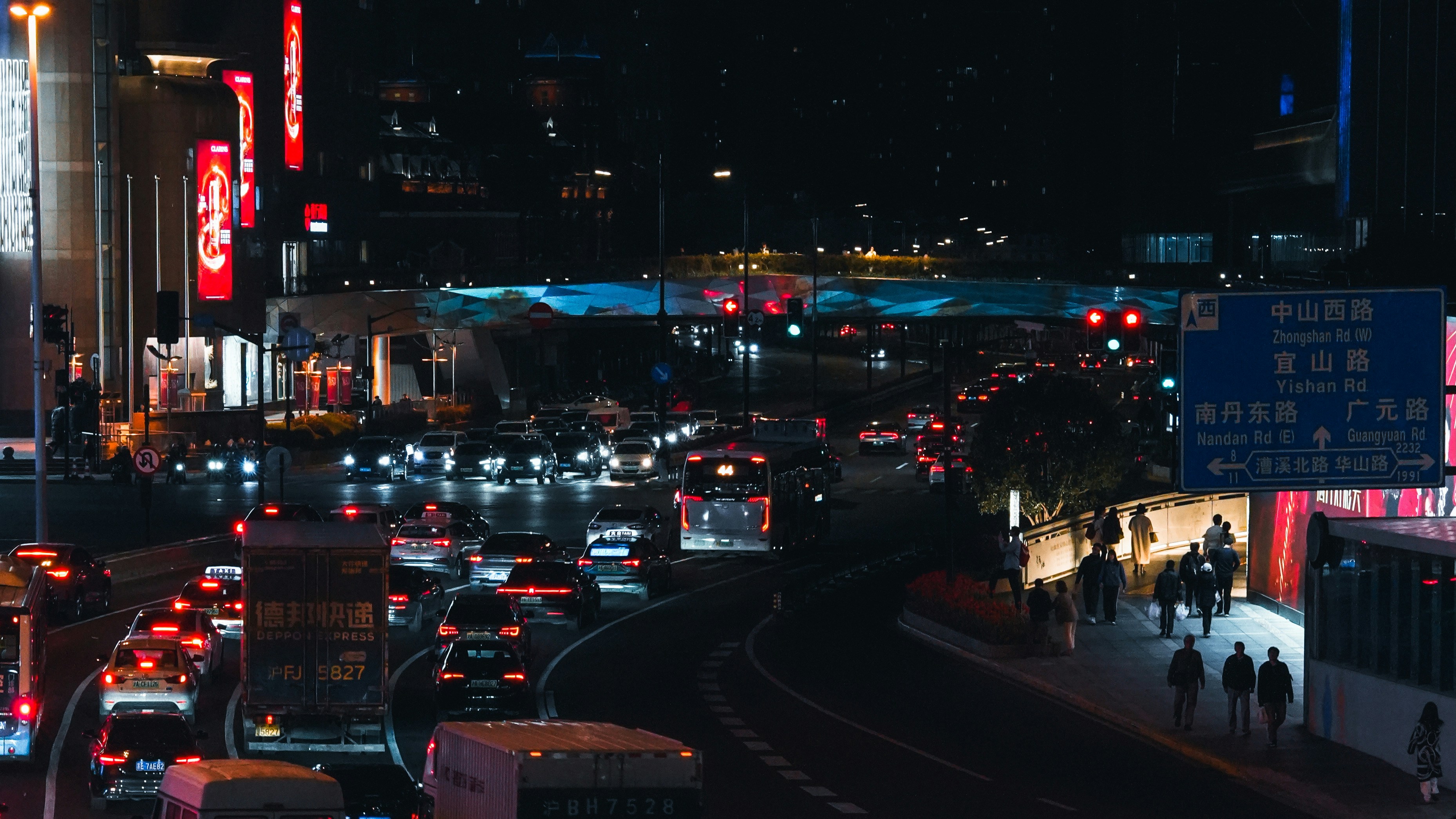 मेट्रो ट्रेन अहमदाबाद के एक आधुनिक स्टेशन पर खड़ी है, पीछे की ओर शहरी क्षितिज दिख रहा है।