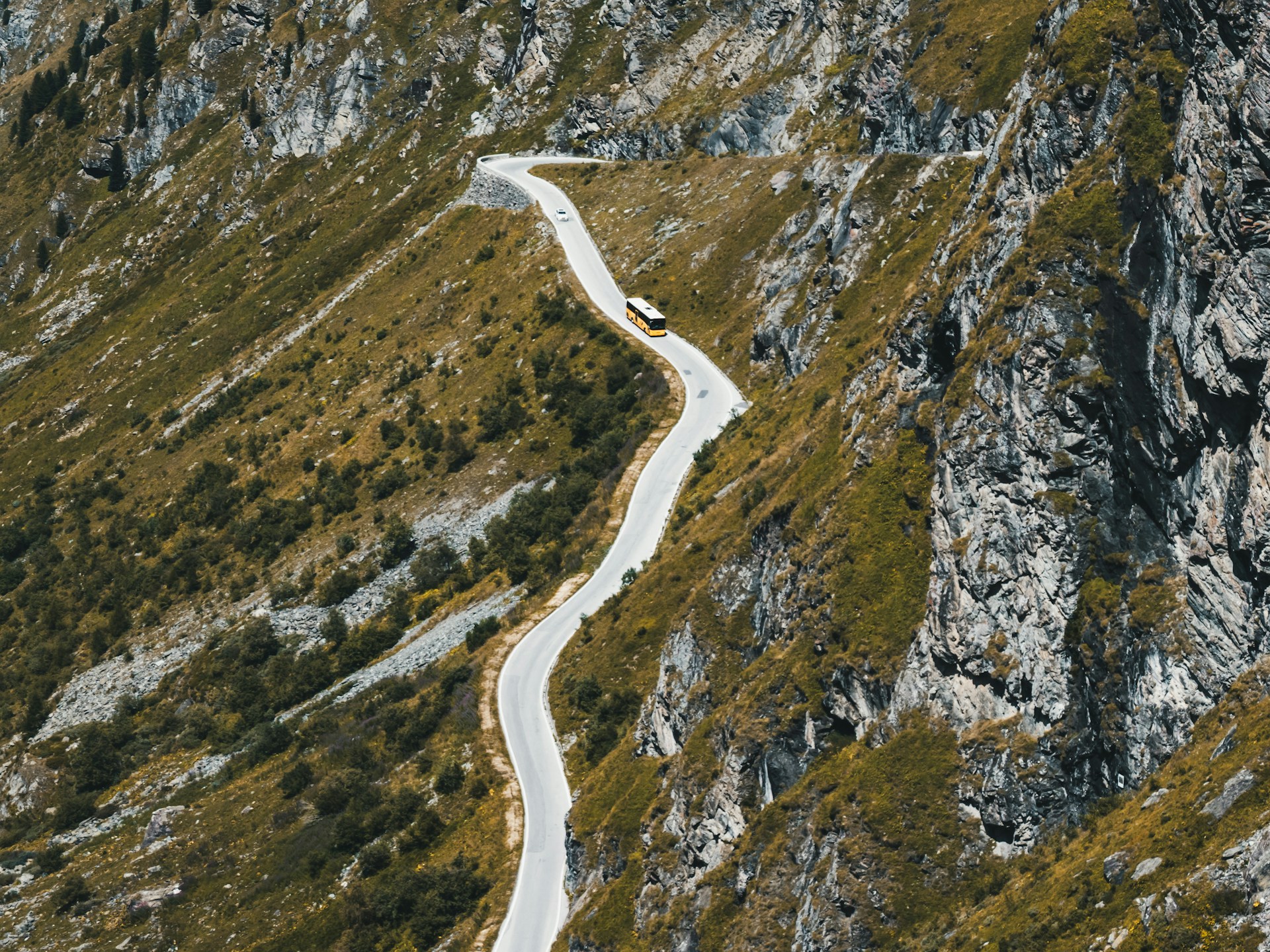 A winding road climbs up the rocky mountain.