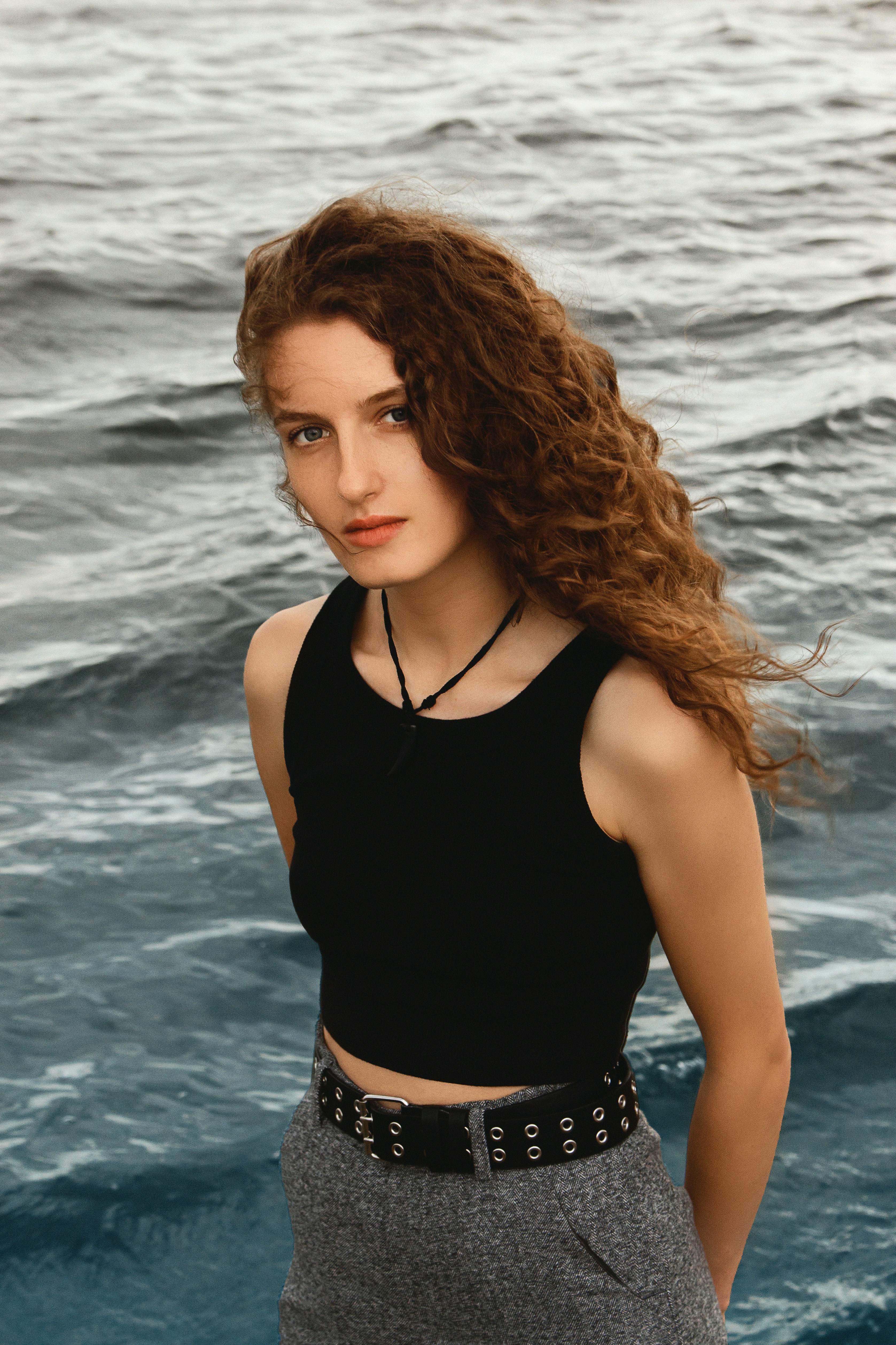 Beautiful woman poses in front of the ocean.