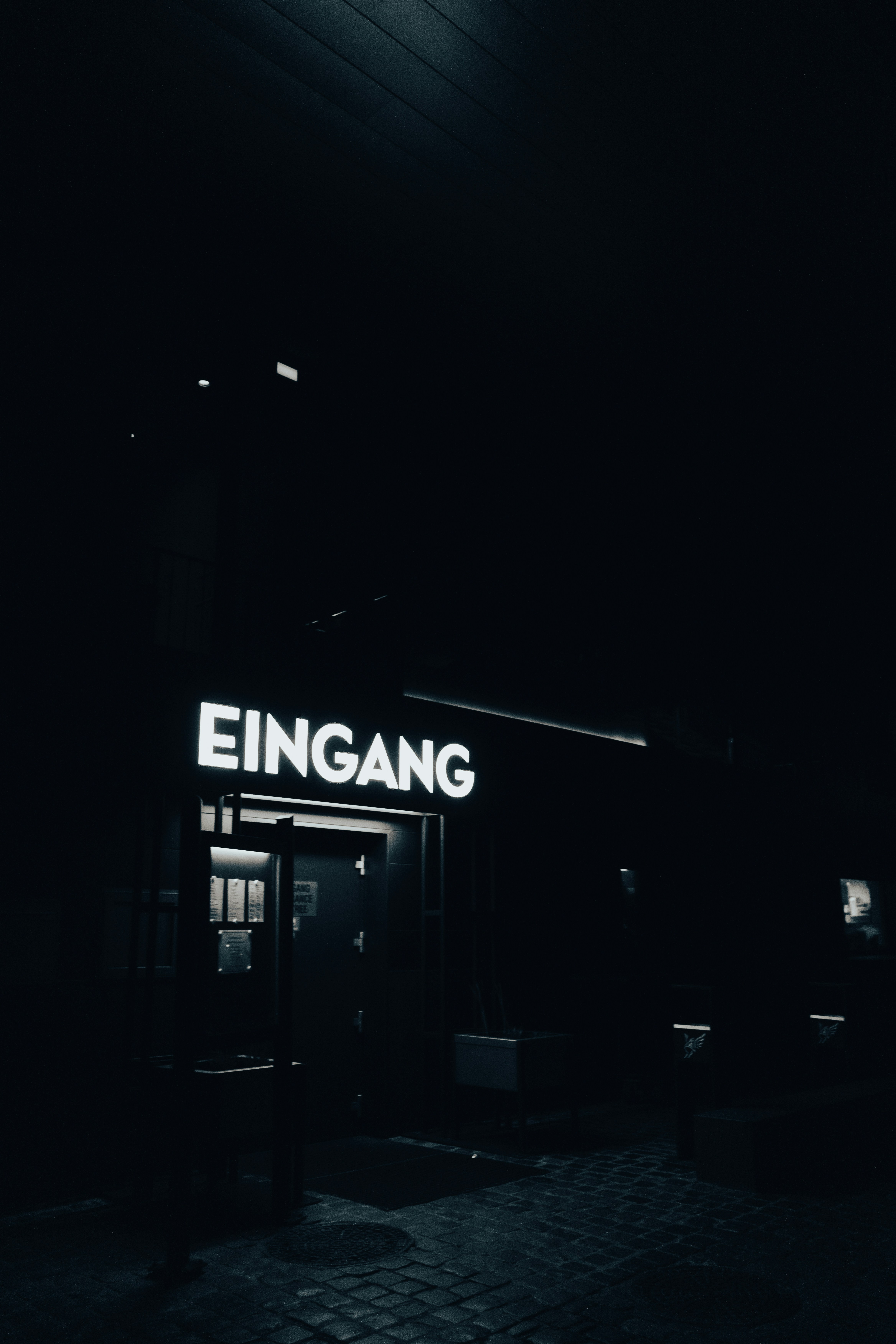 The entrance is brightly lit at night.