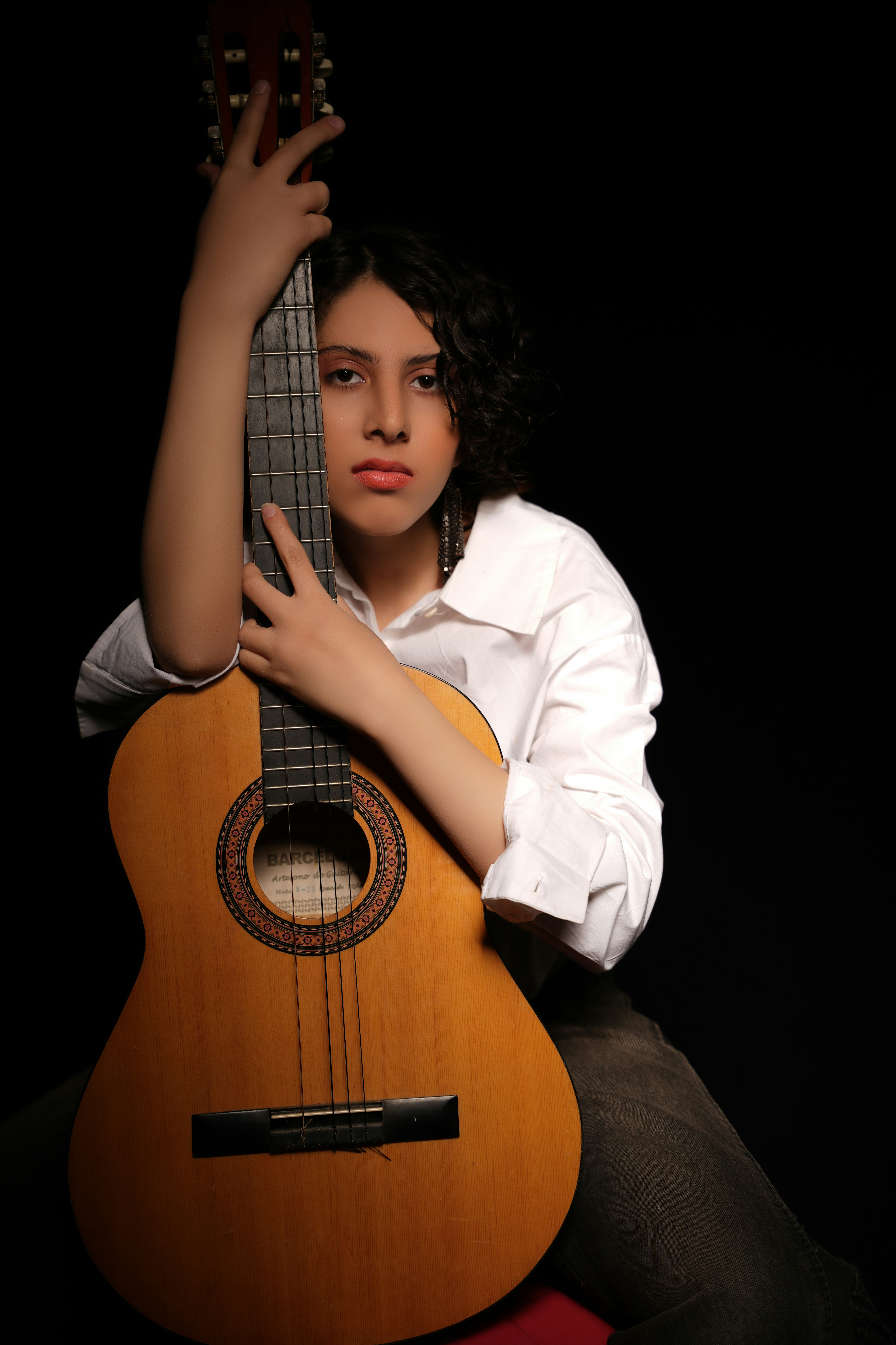 Woman poses with acoustic guitar.
