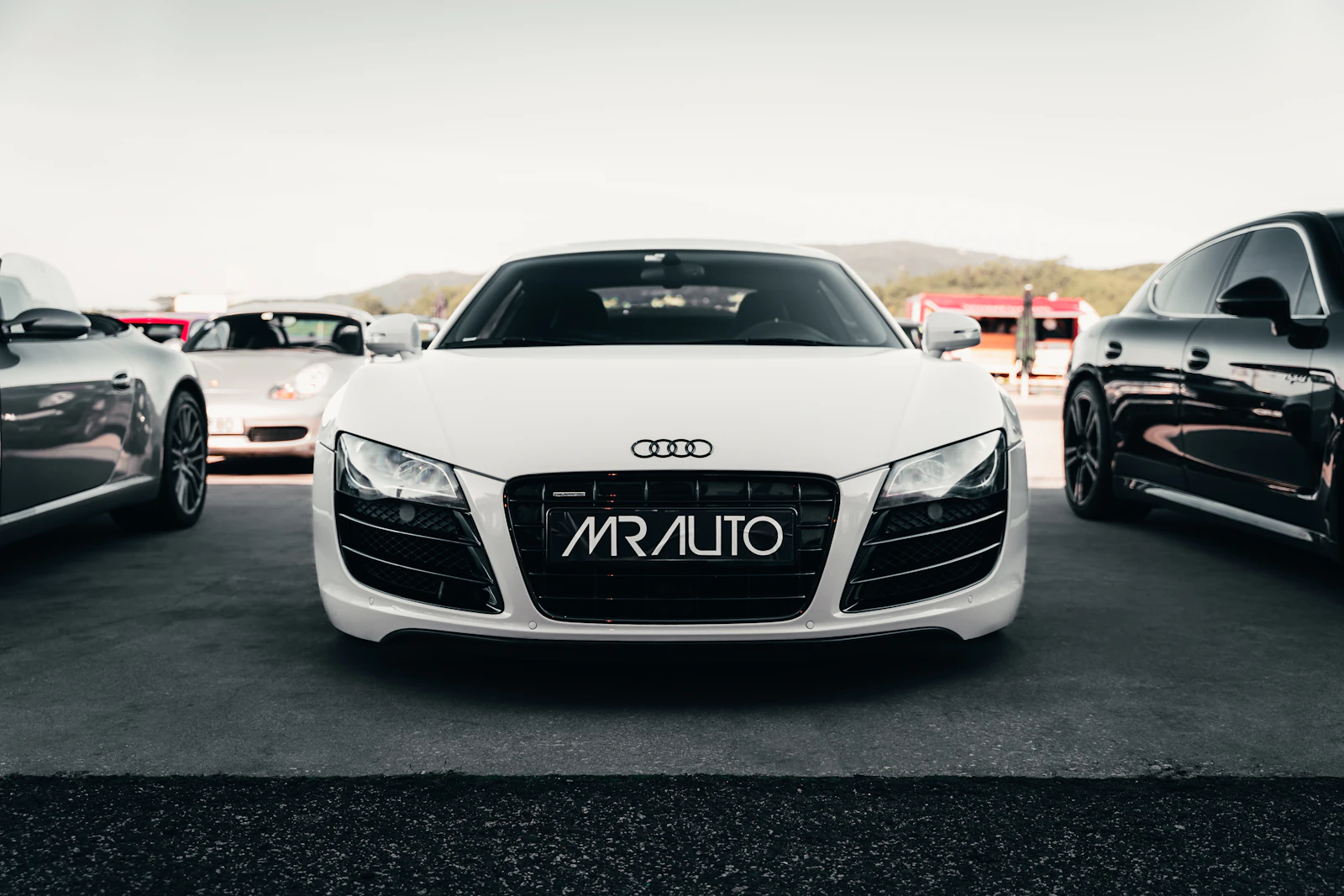 White Audi sports car photographed front-and-center on a racetrack, ideal sleek 4-door coupe cover shot