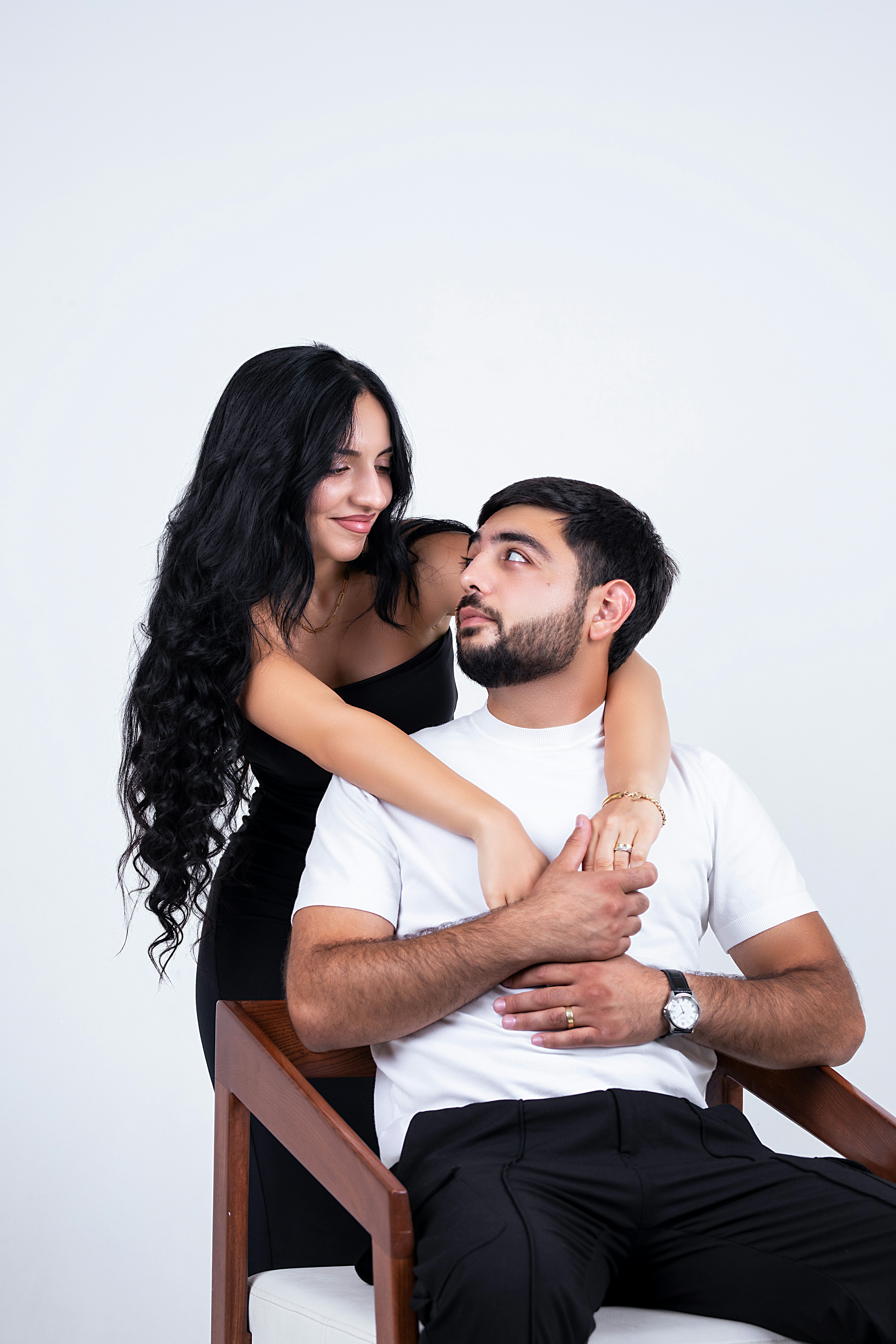 A loving couple poses together in a studio.