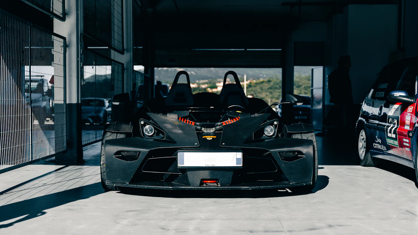 Sporty black car parked in a dark garage at night