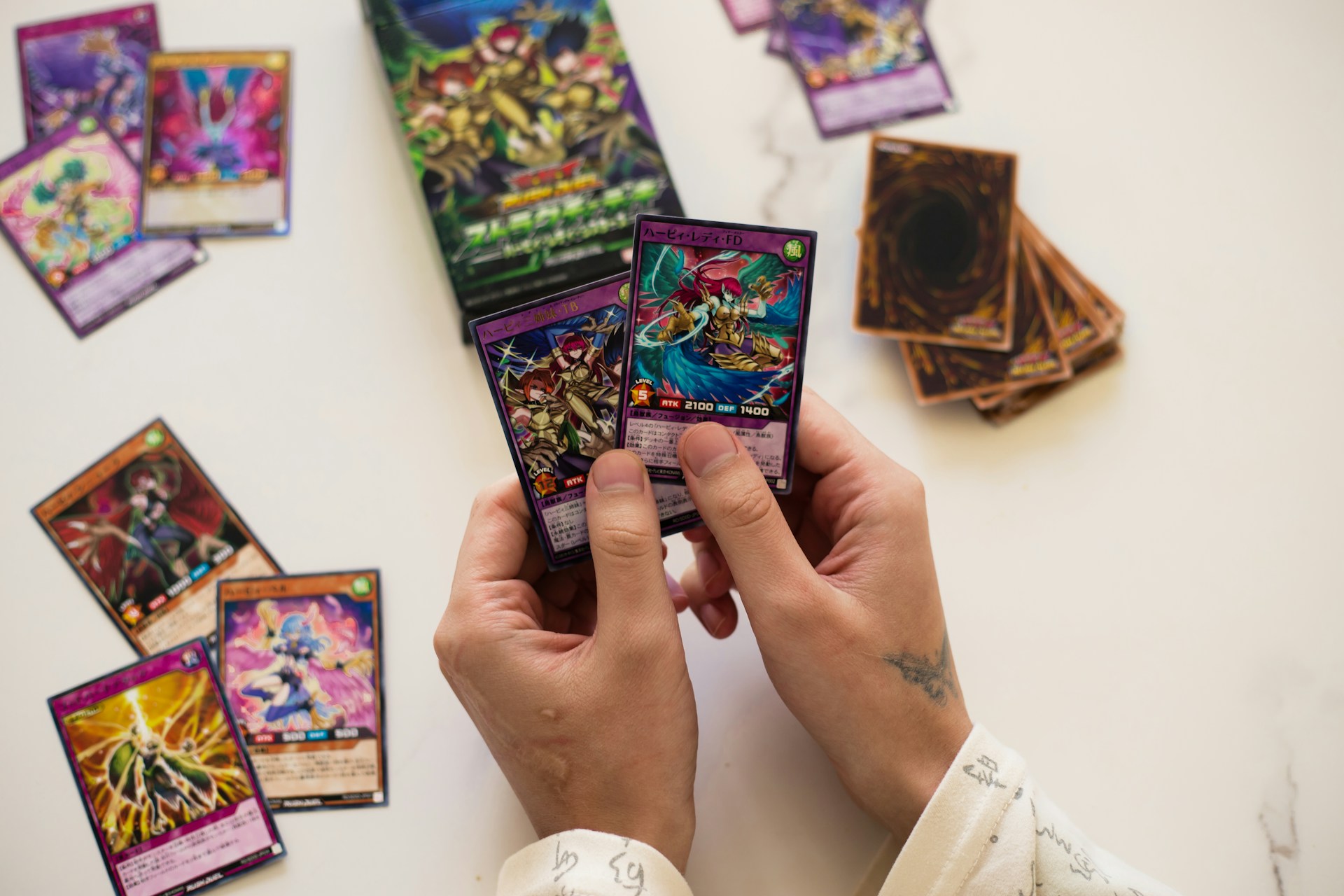 Person is holding yu-gi-oh! cards.